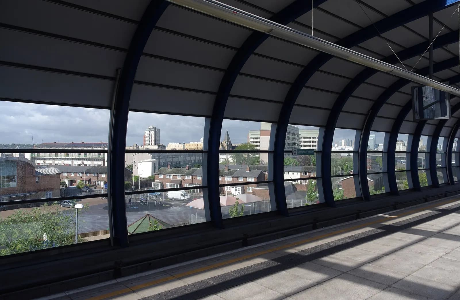 DLR train at London City Airport station with terminal beyond