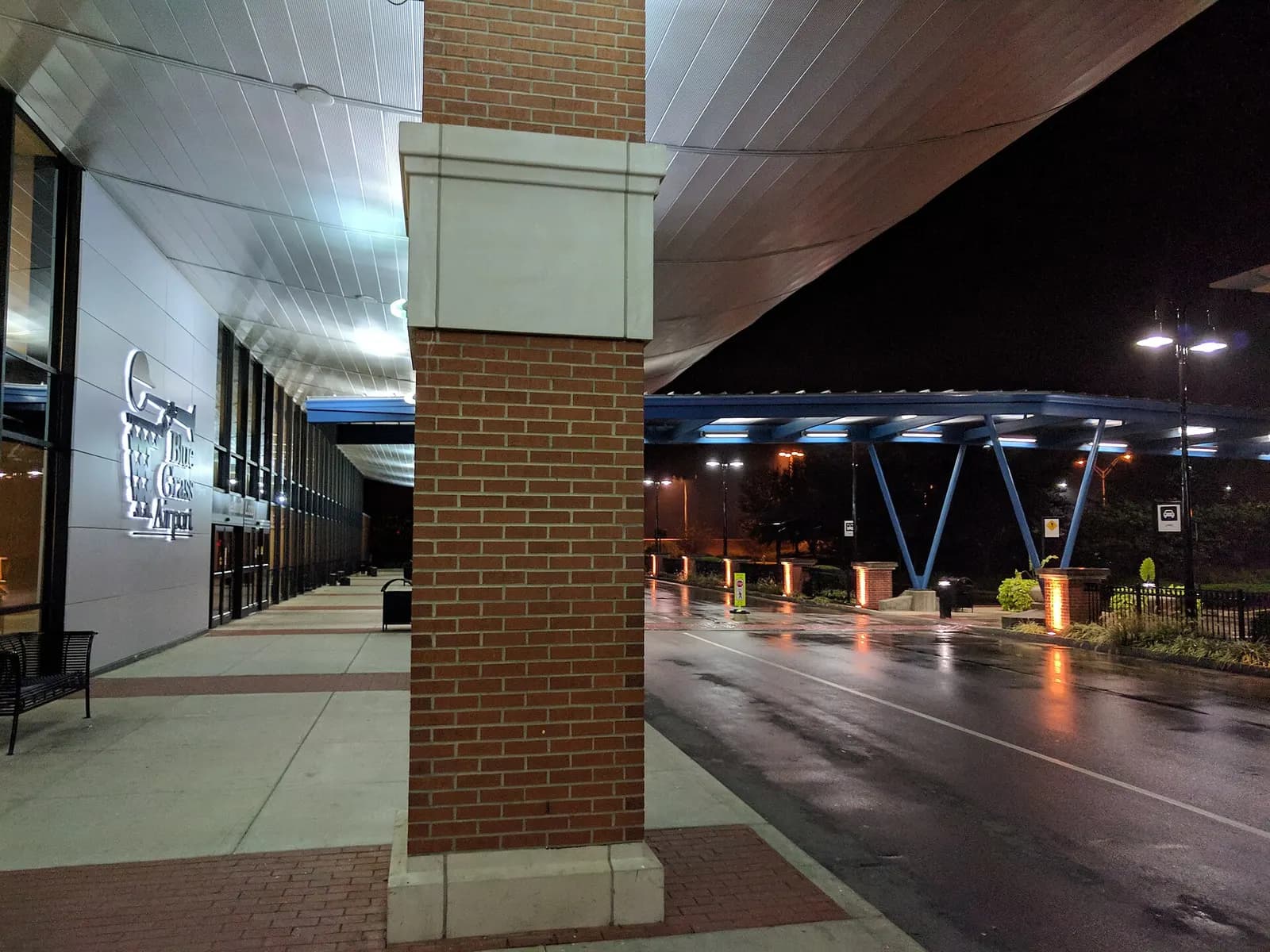 Night curb and Blue Grass Airport wall mark beside a covered walkway, photographed in September 2017.