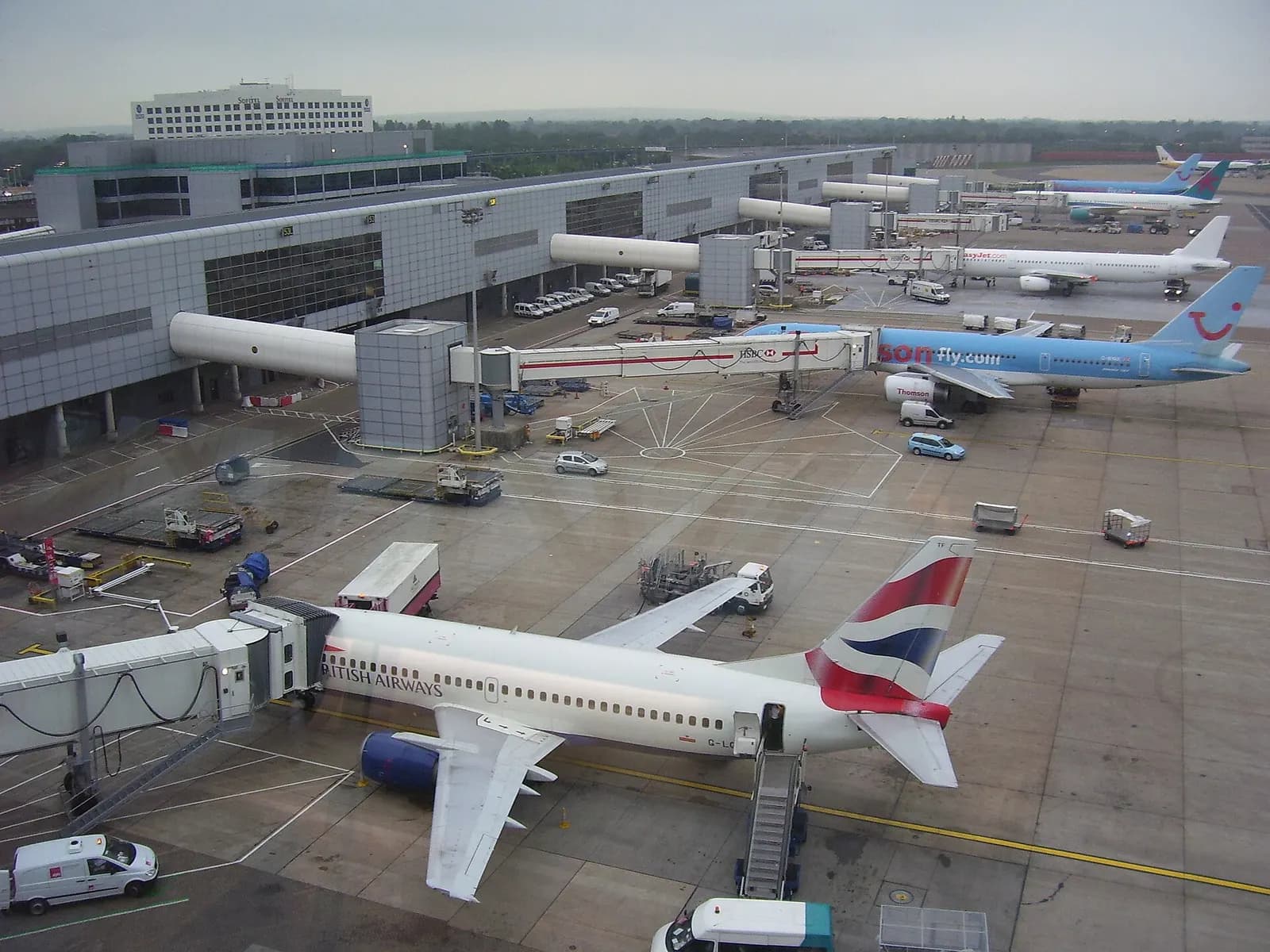 Several passenger aircraft parked at jet bridges along Pier 4 at Gatwick's North Terminal.
