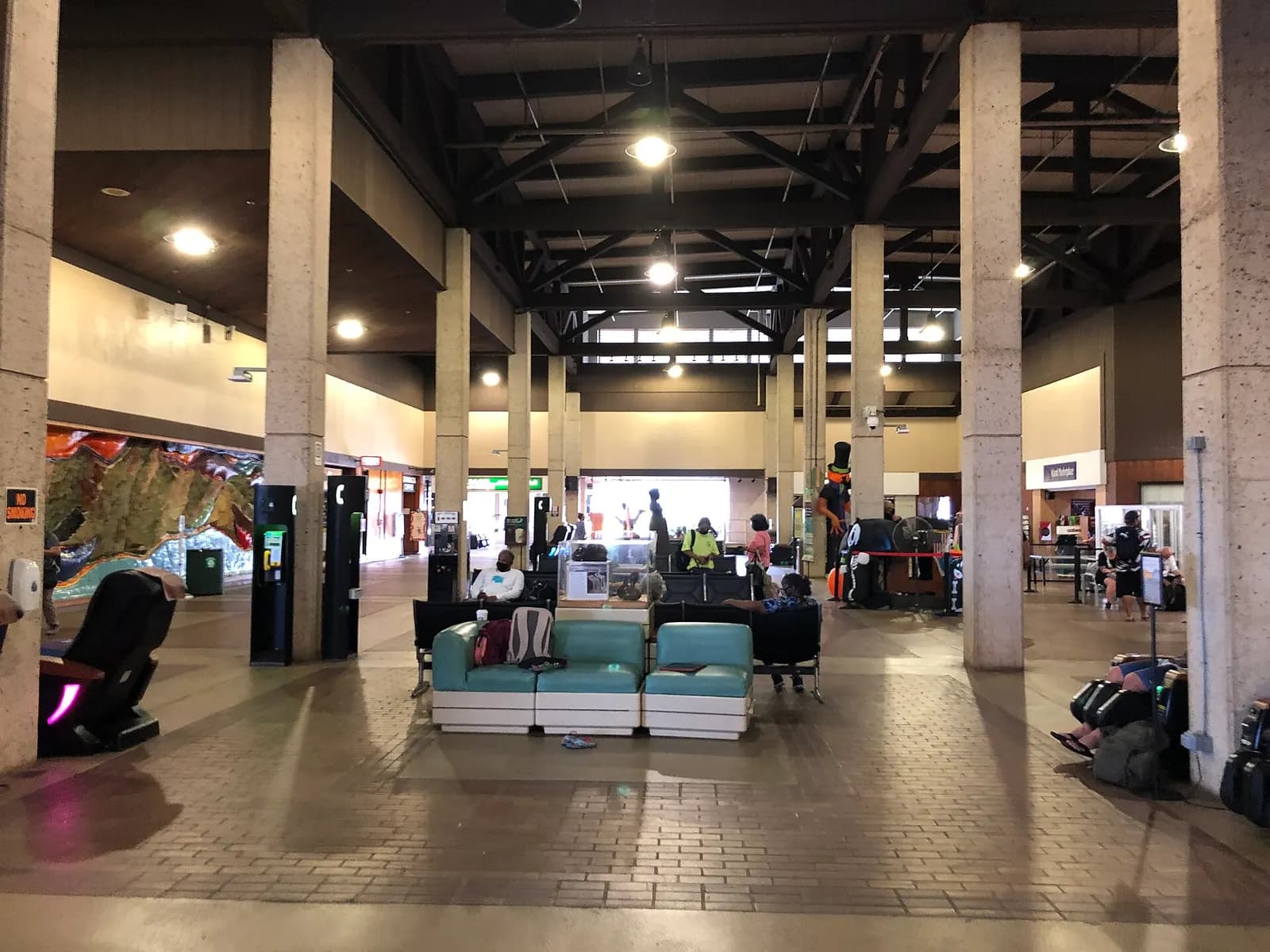 Landside waiting area at Lihue Airport with massage chairs and the open timber ceiling
