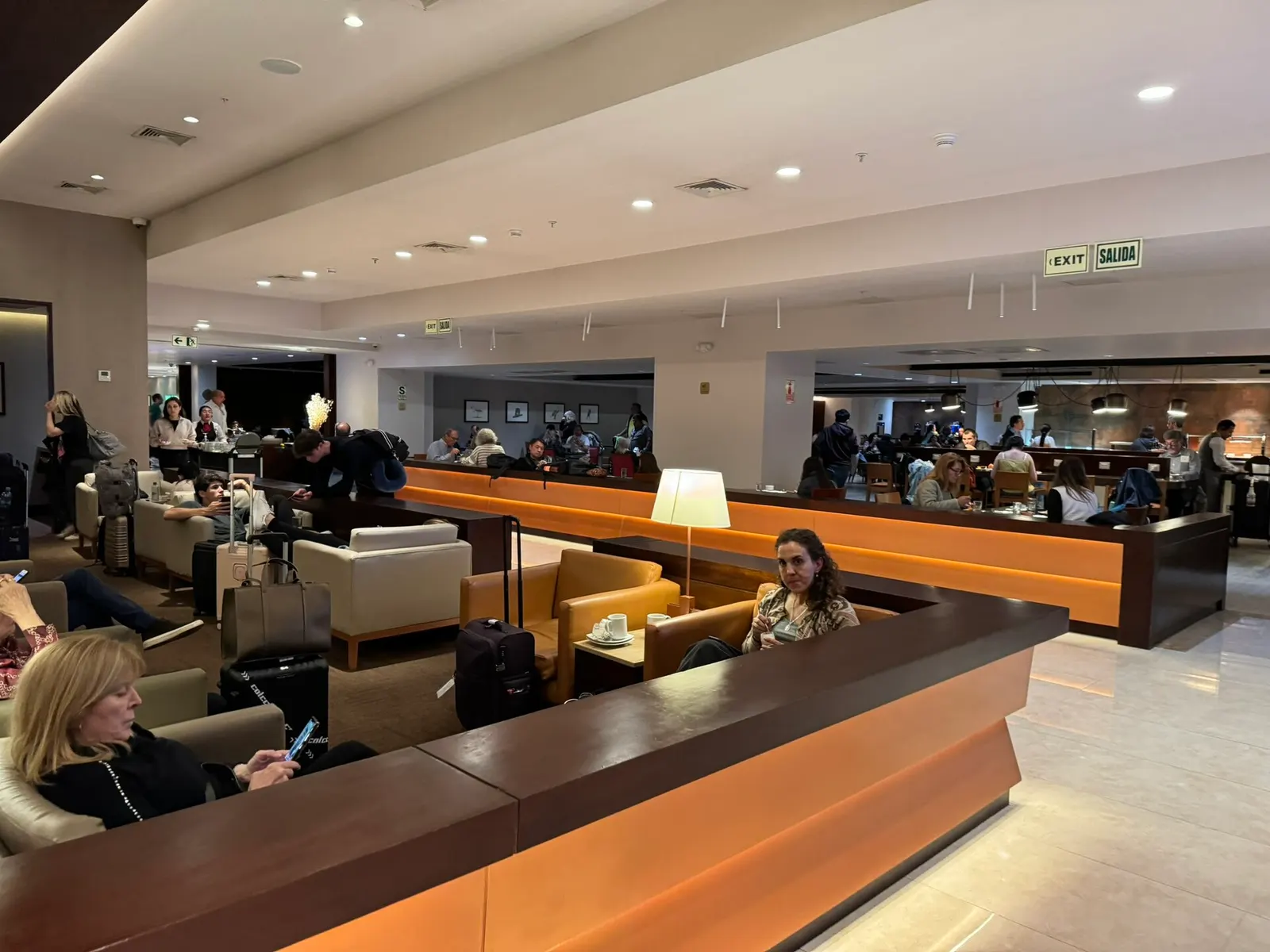 The interior of the SUMAQ VIP lounge with upholstered seating, tables, and a quiet waiting area for premium passengers.
