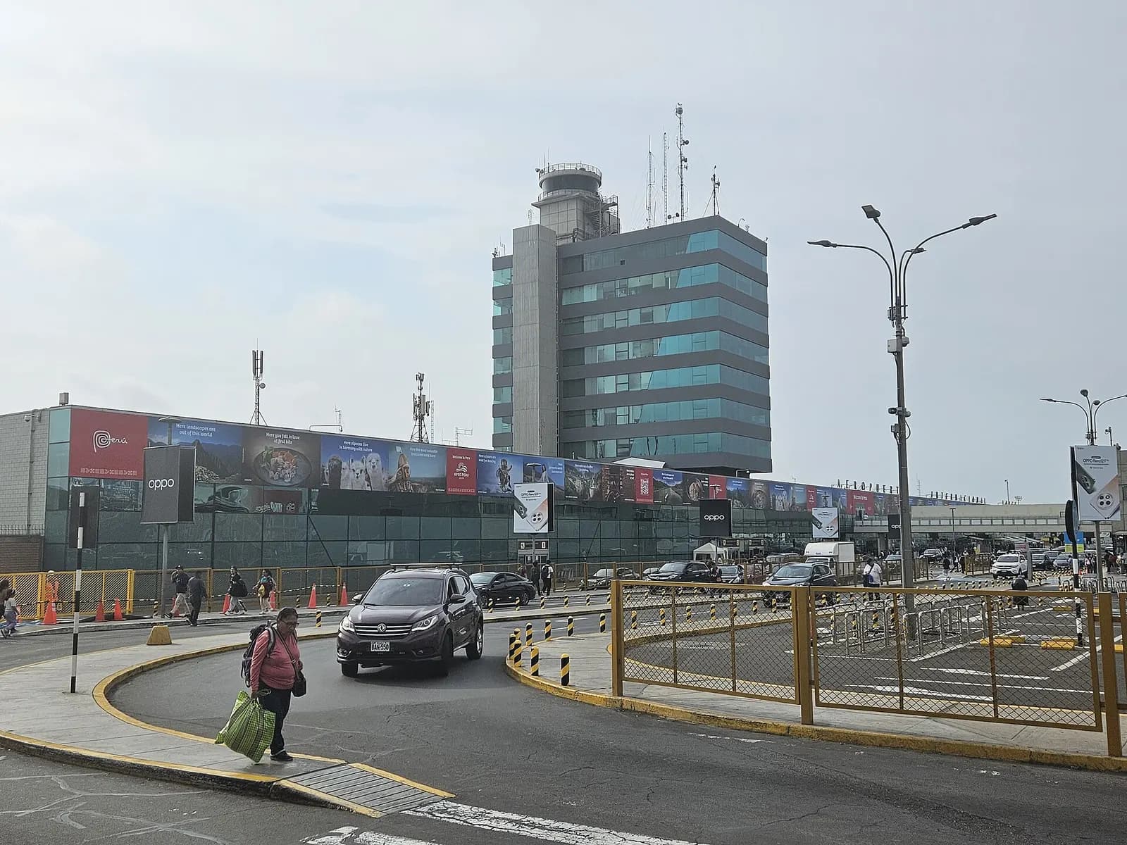 The roadway and passenger drop-off lanes leading into Jorge Chávez International Airport, with the terminal visible ahead.