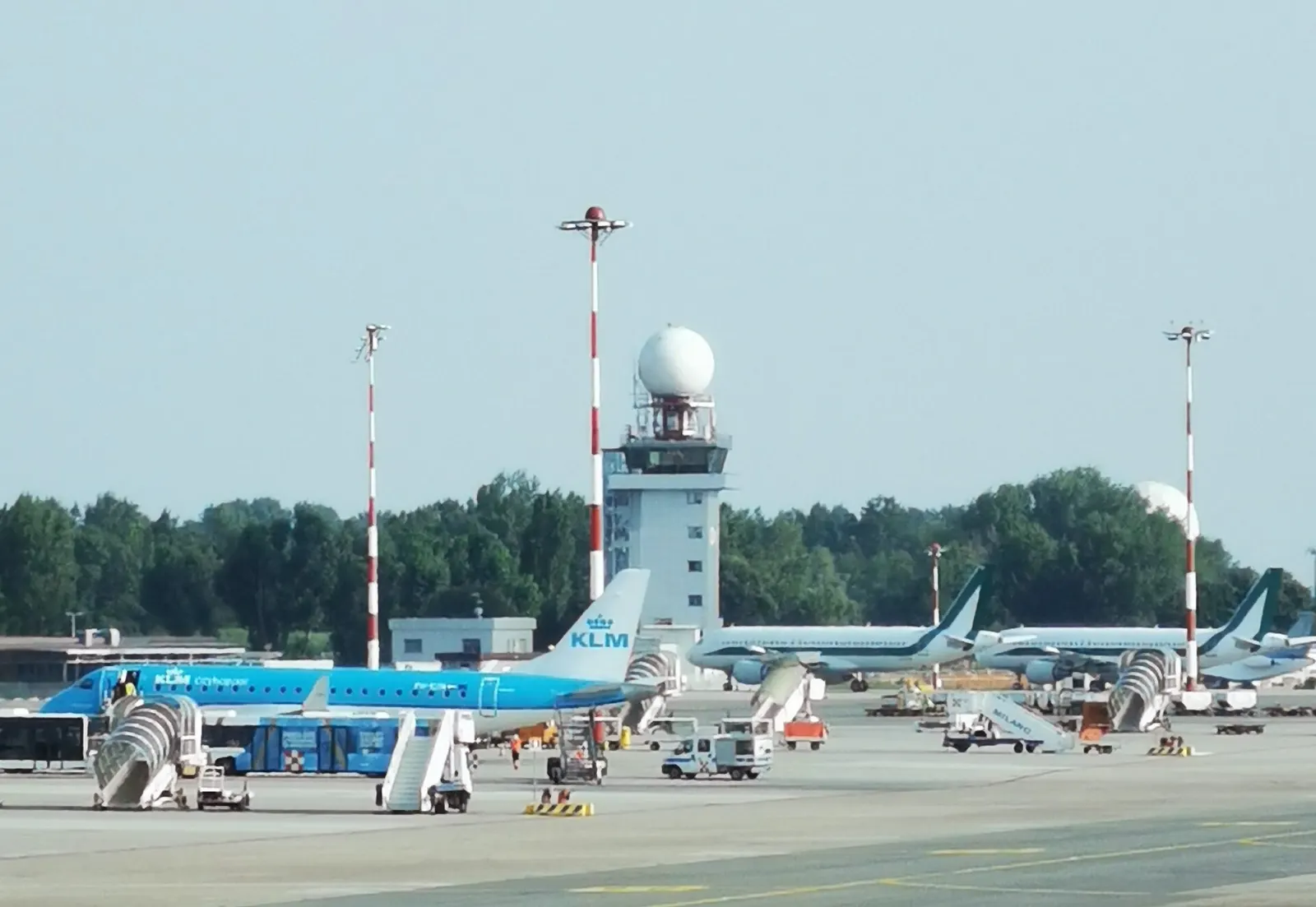 Torre di controllo dell'aeroporto di Milano Linate, con alla base un Embraer 190 di KLM Cityhopper.