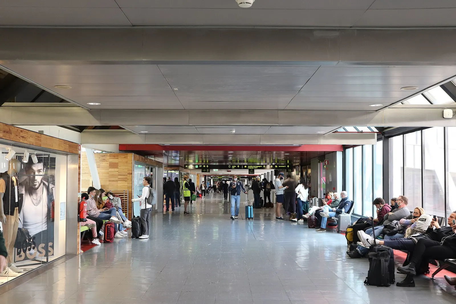 A wide view of the bright, open concourse inside Terminal 1 with check-in counters and passenger walkways.