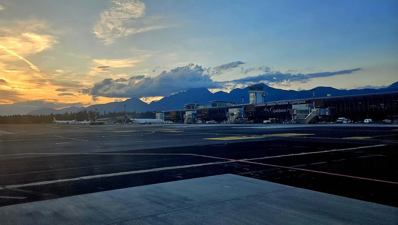 Ljubljana Airport terminal exterior at dusk, July 2024