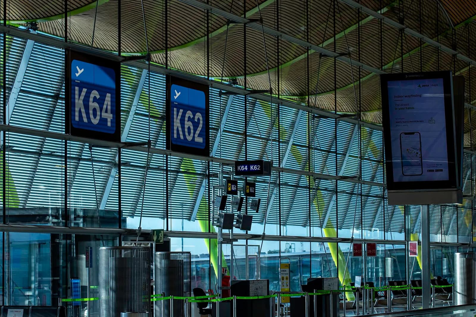 The T4 departures concourse near boarding gates K62 and K64, with directional signage and passengers walking toward the gates.