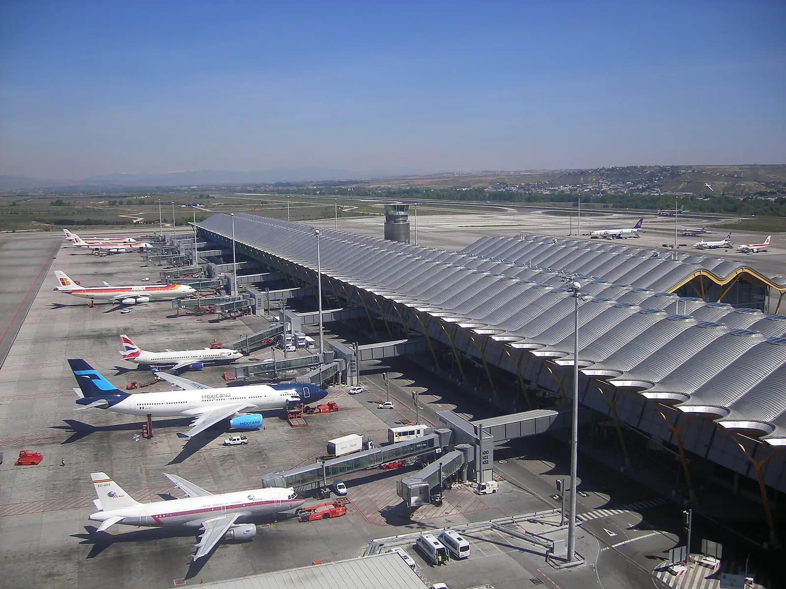 The satellite pier of Terminal 4S with its undulating roofline, seen from the airfield with aircraft parked at the gates.