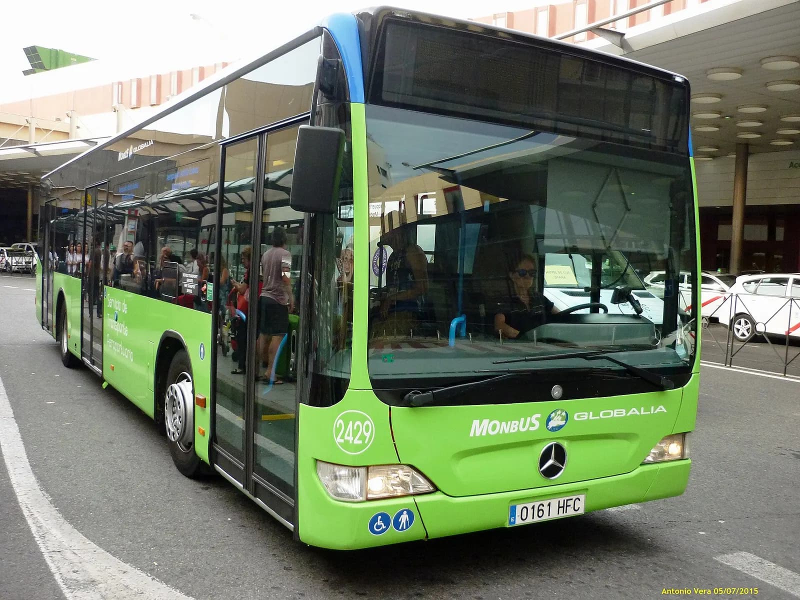 A Monbus coach parked outside the airport terminal buildings, used for public and regional bus services.