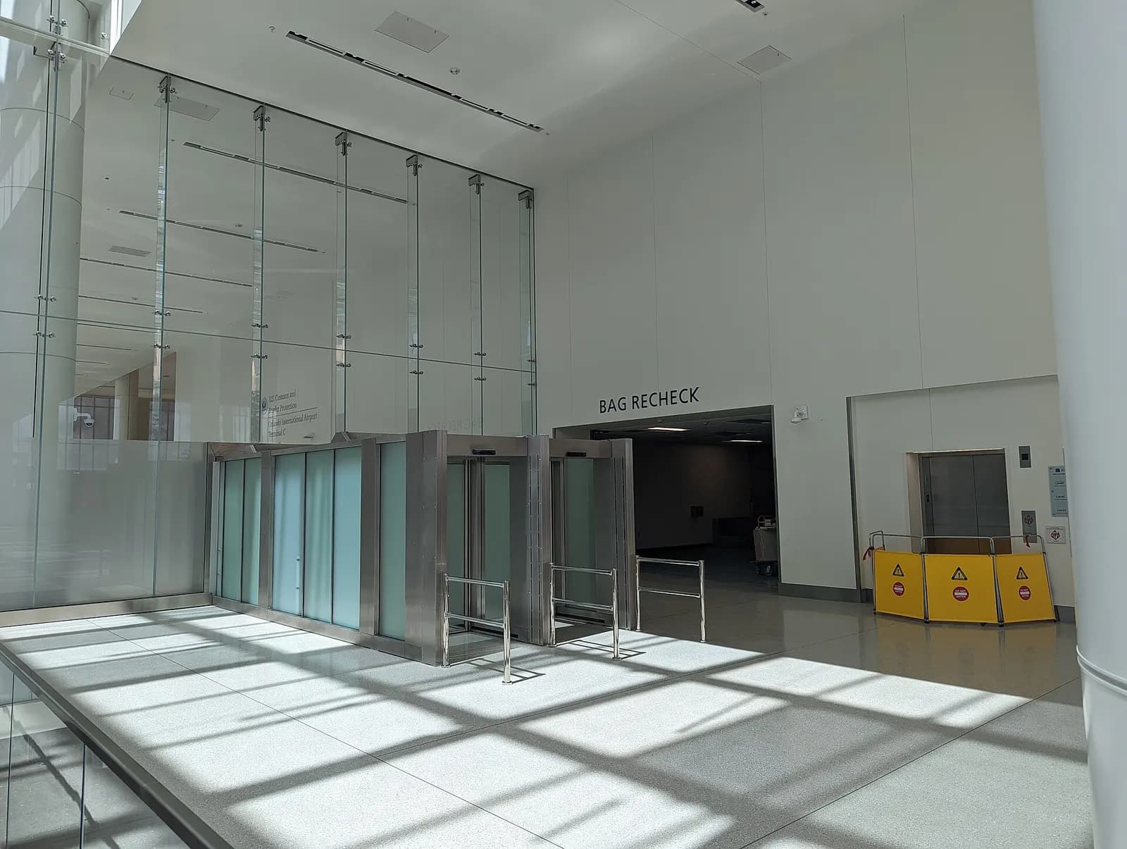Orlando International Airport Terminal C Opening Day. The bag recheck area can be seen, with the Customs & Border Control sign on the other side of the security barrier