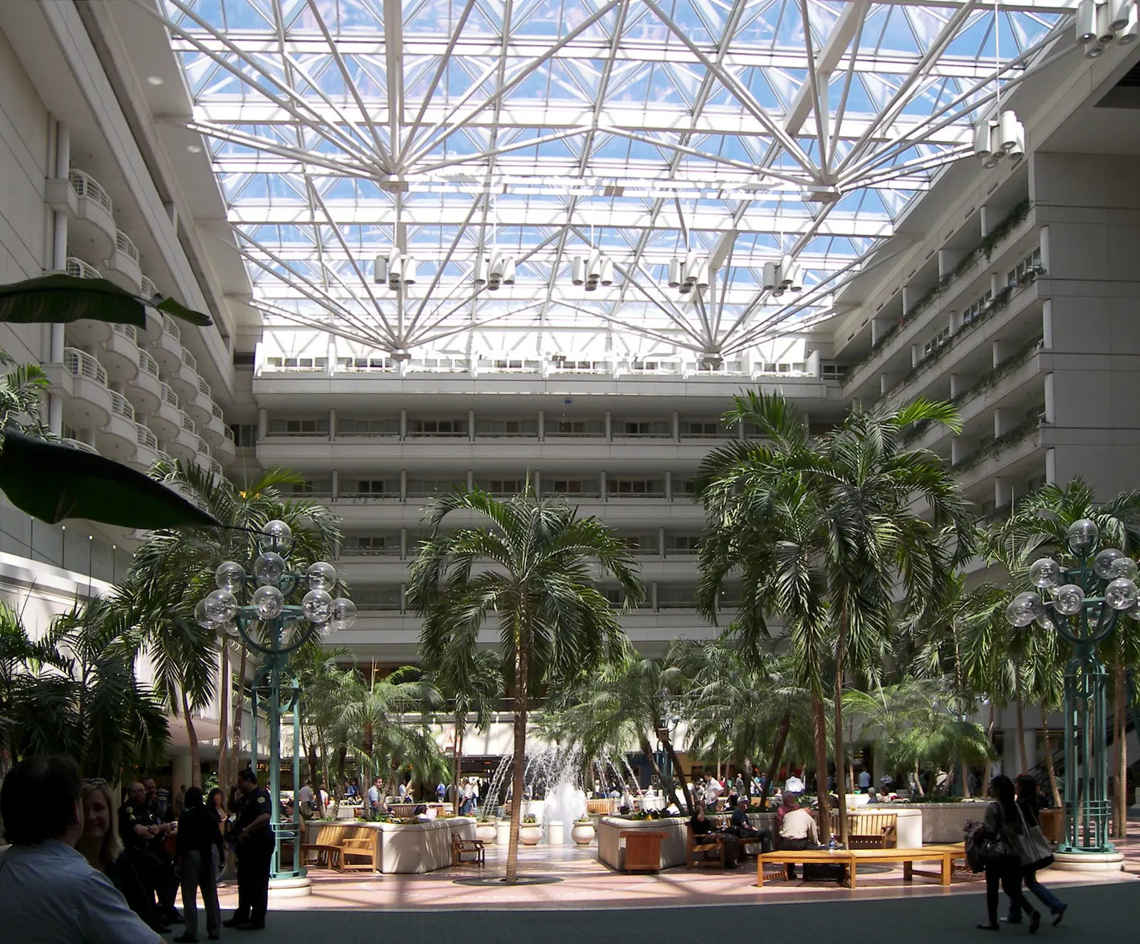 The spacious main atrium inside Orlando International Airport with high ceilings, palm trees, and natural light flooding the central terminal hall.