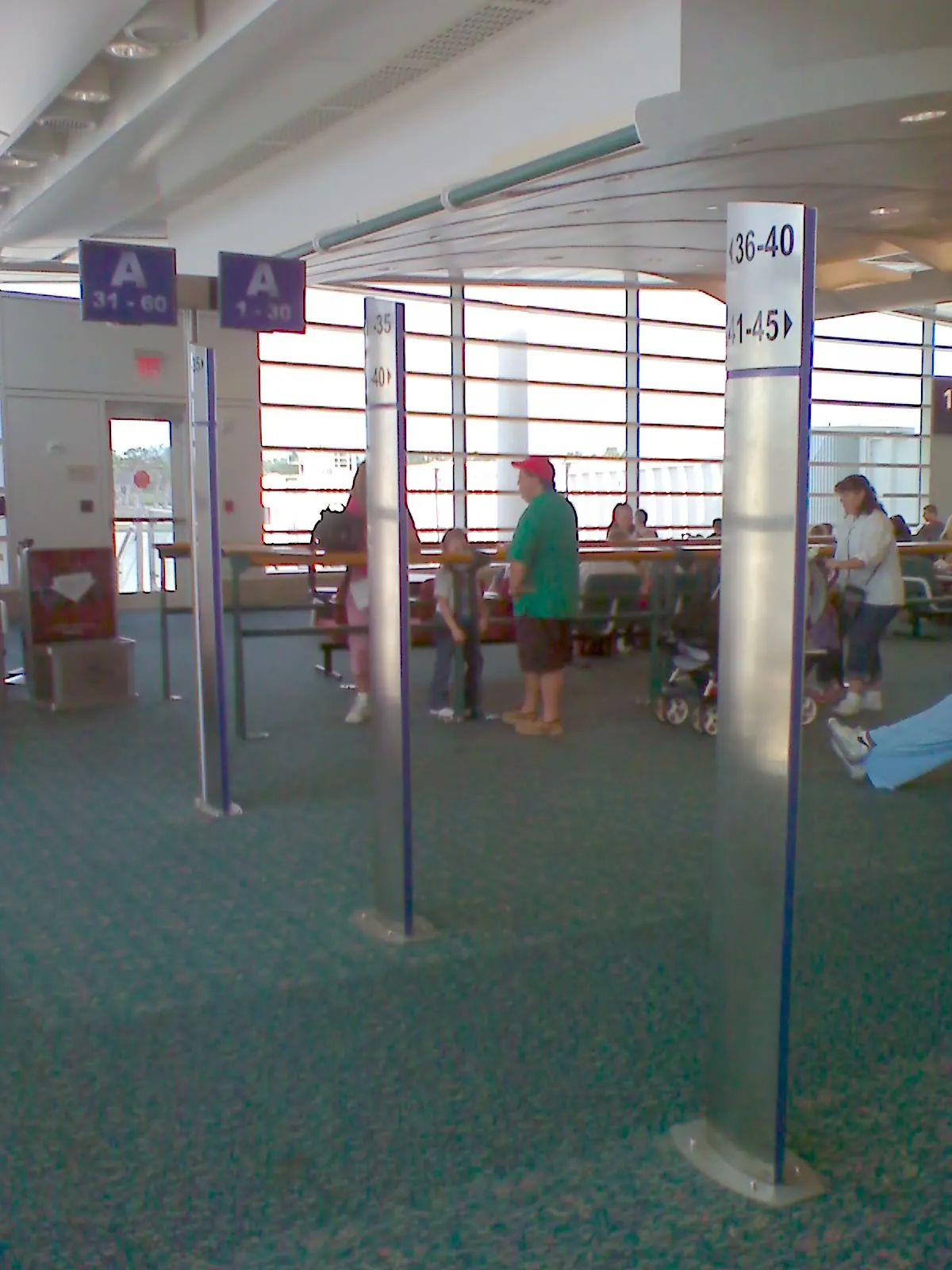 The Southwest Airlines gate seating area at Orlando International Airport with passengers waiting near boarding counters and large terminal windows.