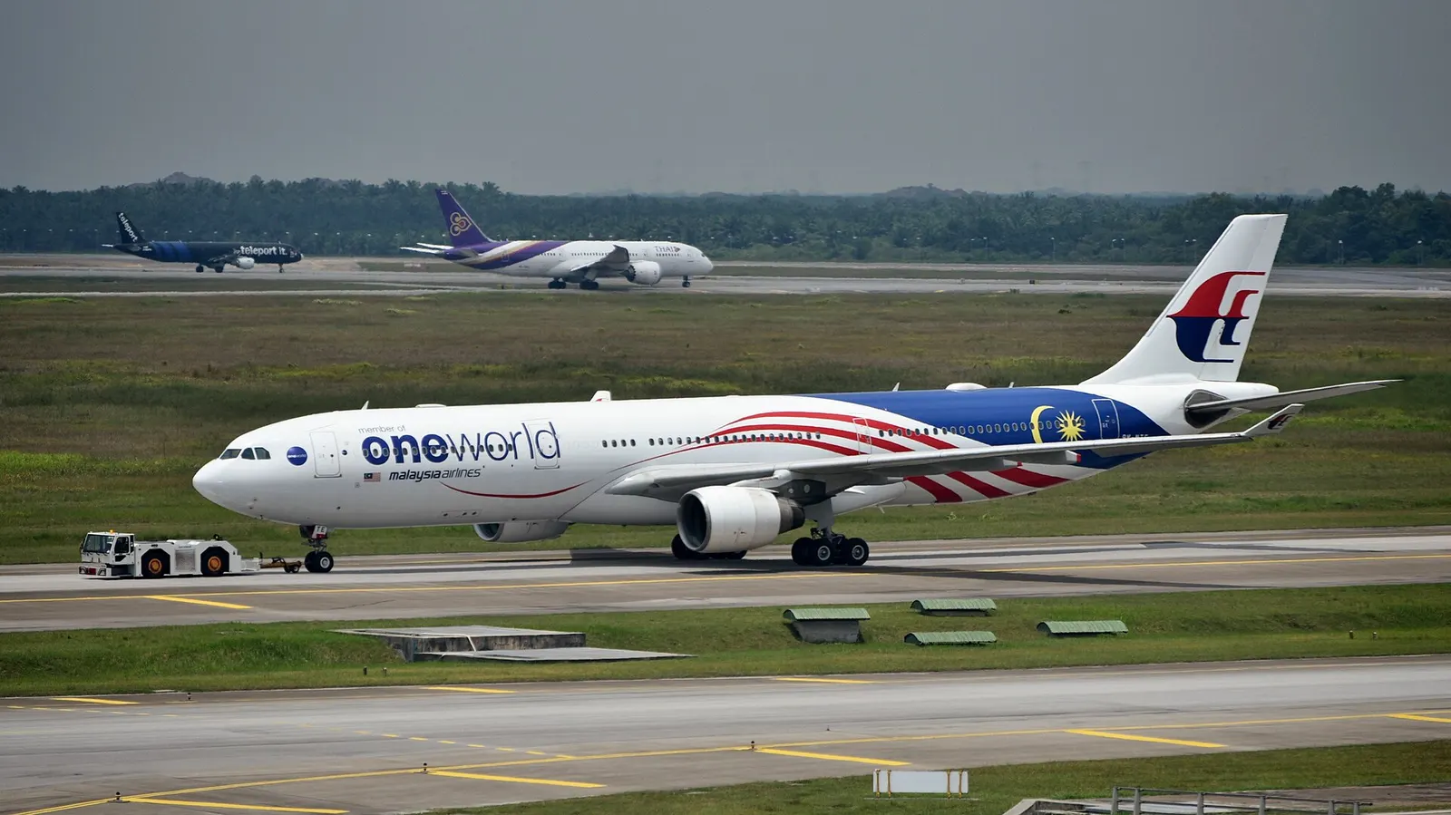 Malaysia Airlines Airbus A330-323 9M-MTE, in OneWorld livery, being towed to the Satellite Building of Terminal 1 at Kuala Lumpur International Airport (KUL/WMKK), near Kuala Lumpur, Malaysia, ahead of its departure for Melbourne Airport (MEL/YMML) as MH149