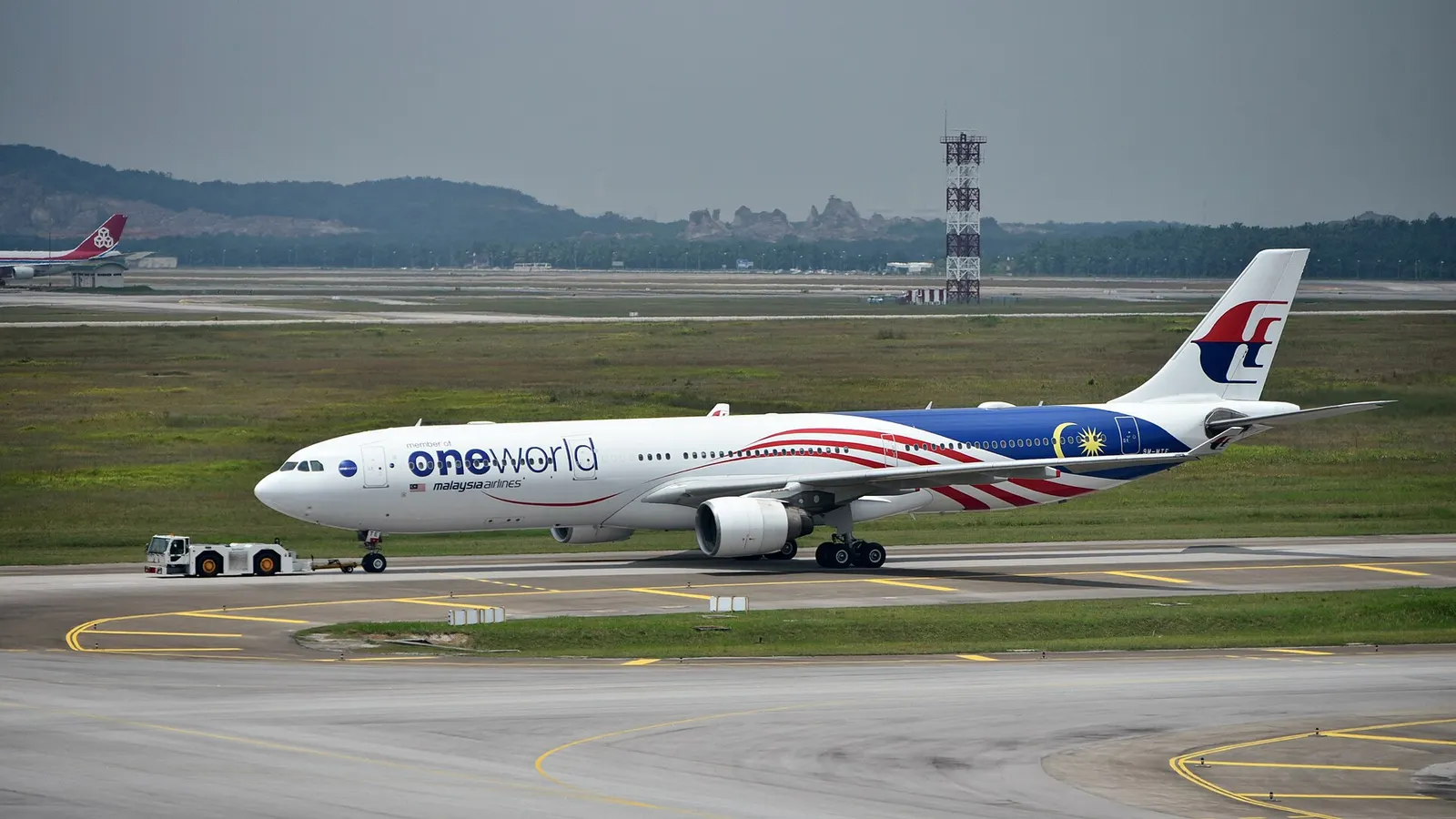 Malaysia Airlines Airbus A330-323 9M-MTE, in OneWorld livery, being towed to the Satellite Building of Terminal 1 at Kuala Lumpur International Airport (KUL/WMKK), near Kuala Lumpur, Malaysia, ahead of its departure for Melbourne Airport (MEL/YMML) as MH149