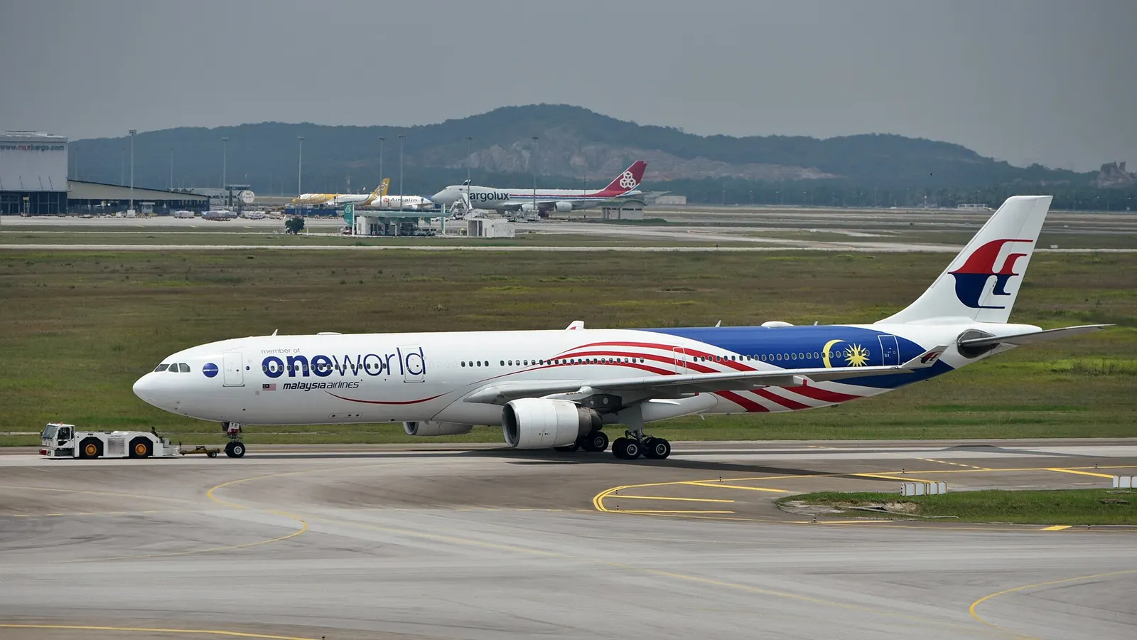 Malaysia Airlines Airbus A330-323 9M-MTE, in OneWorld livery, being towed to the Satellite Building of Terminal 1 at Kuala Lumpur International Airport (KUL/WMKK), near Kuala Lumpur, Malaysia, ahead of its departure for Melbourne Airport (MEL/YMML) as MH149