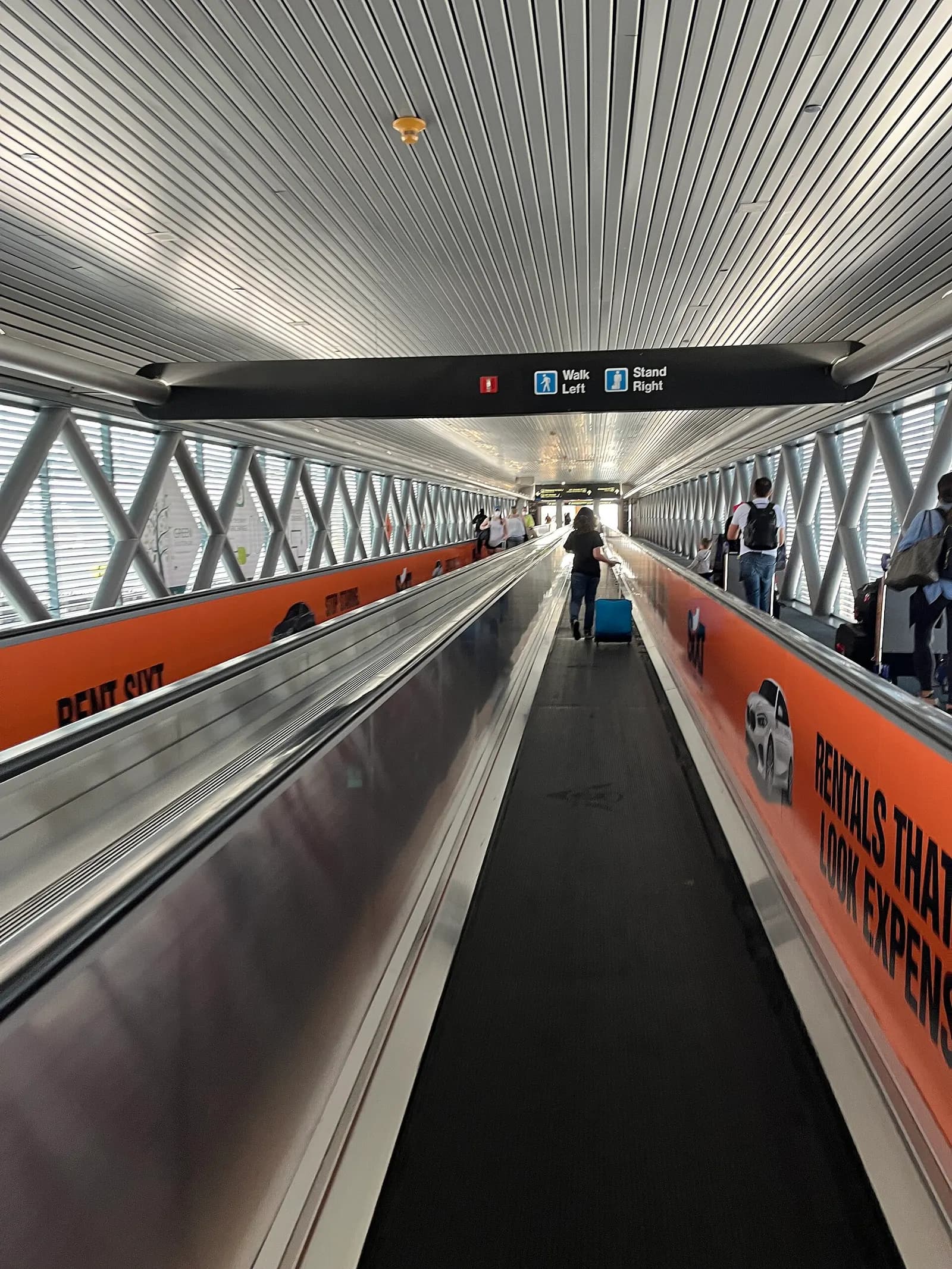 A moving walkway leading from the MIA Metrorail/MIA Mover station toward a terminal entrance.