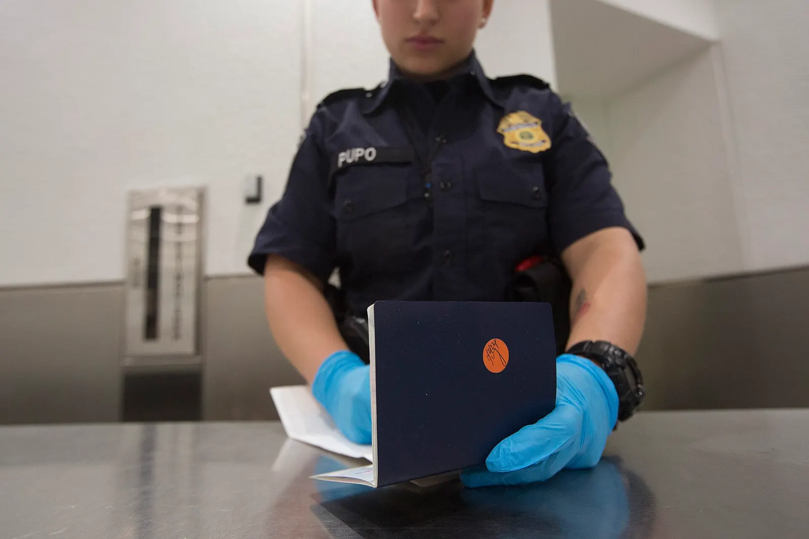 U.S. Customs and Border Protection officers screening arriving international passengers at immigration counters inside MIA.