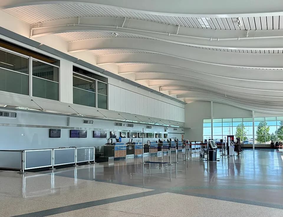 Check-in counters and a kiosk in the Minot International Airport lobby, with a United sign visible.