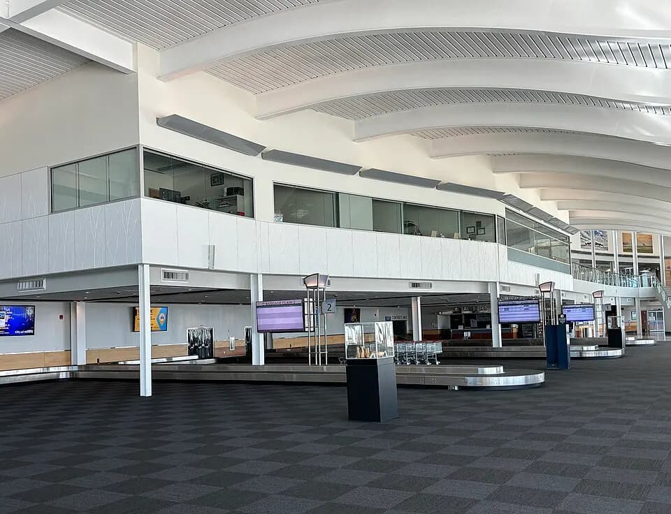 Baggage carousel and mezzanine glass offices in the Minot International Airport arrivals hall.