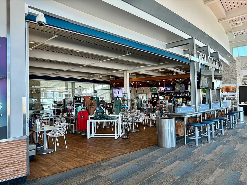 The Trestle Tap House bar, gift racks, and seating after security at Minot International Airport.