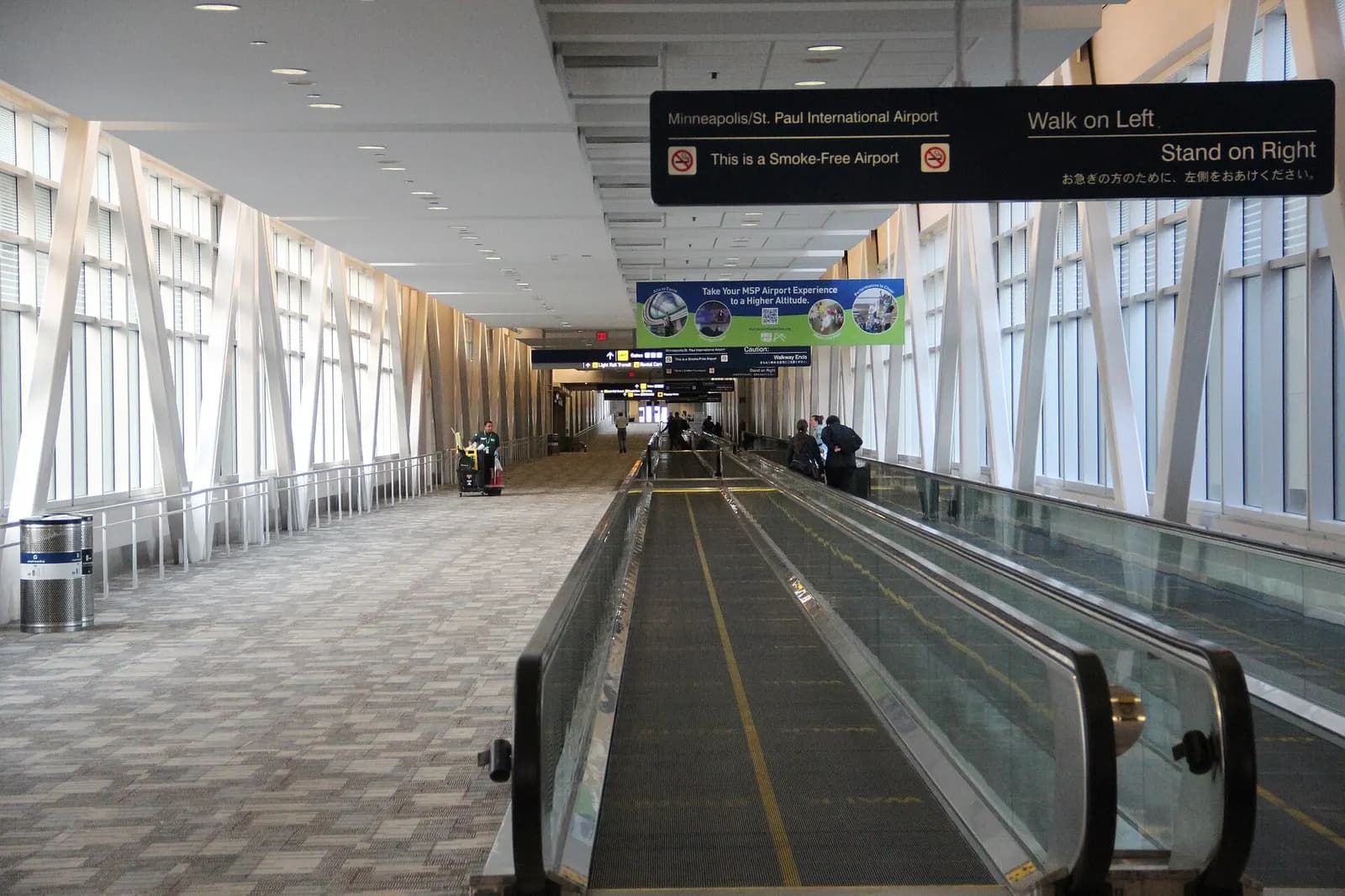 Wide view of the bright, modern main hall of Terminal 1 at Minneapolis–Saint Paul International Airport with high ceilings, signage, and passenger walkways.