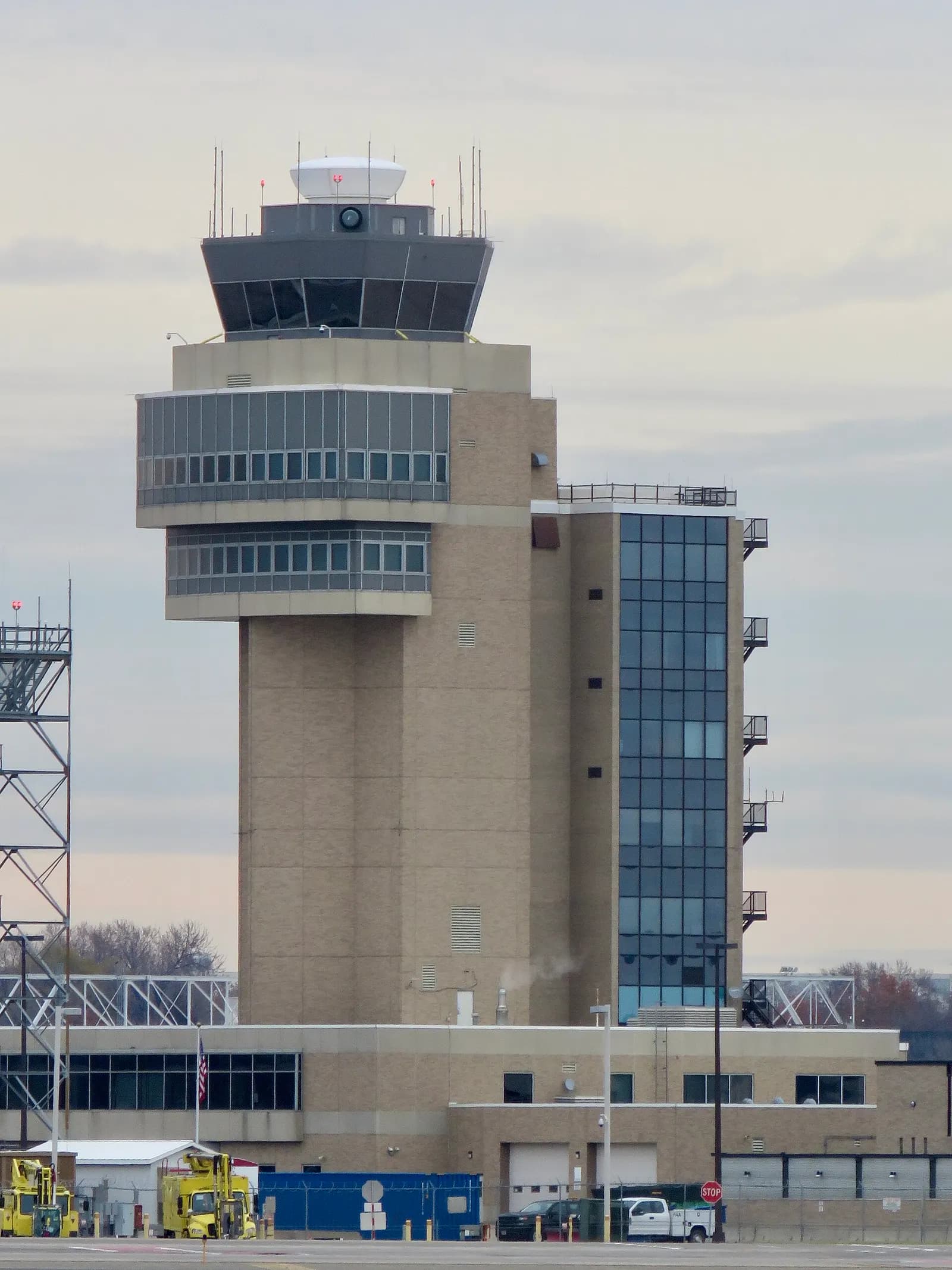 The tall air traffic control tower at Minneapolis–Saint Paul International Airport rising above the terminal buildings against a cloudy sky.