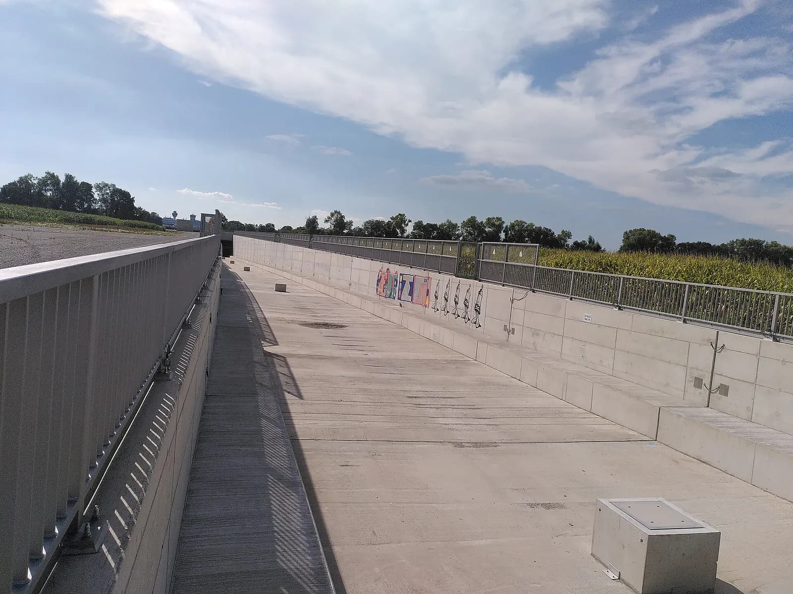 The eastern portal of the S-Bahn rail tunnel passes beneath Munich Airport, with concrete walls and track bed visible at the entrance.