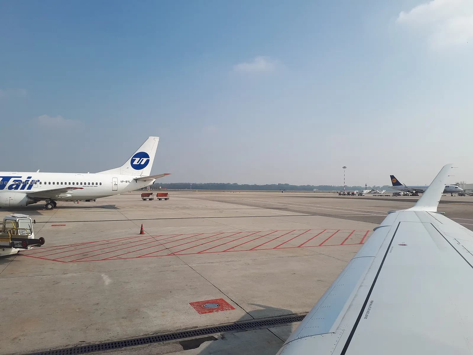 Passenger view from inside Milan Malpensa Airport looking out toward the terminal complex and airfield.