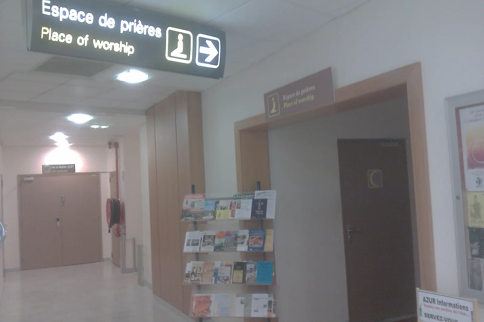 Entrance corridor to the airport's multi-faith prayer rooms, with signs for Muslim, Christian, and Jewish spaces.