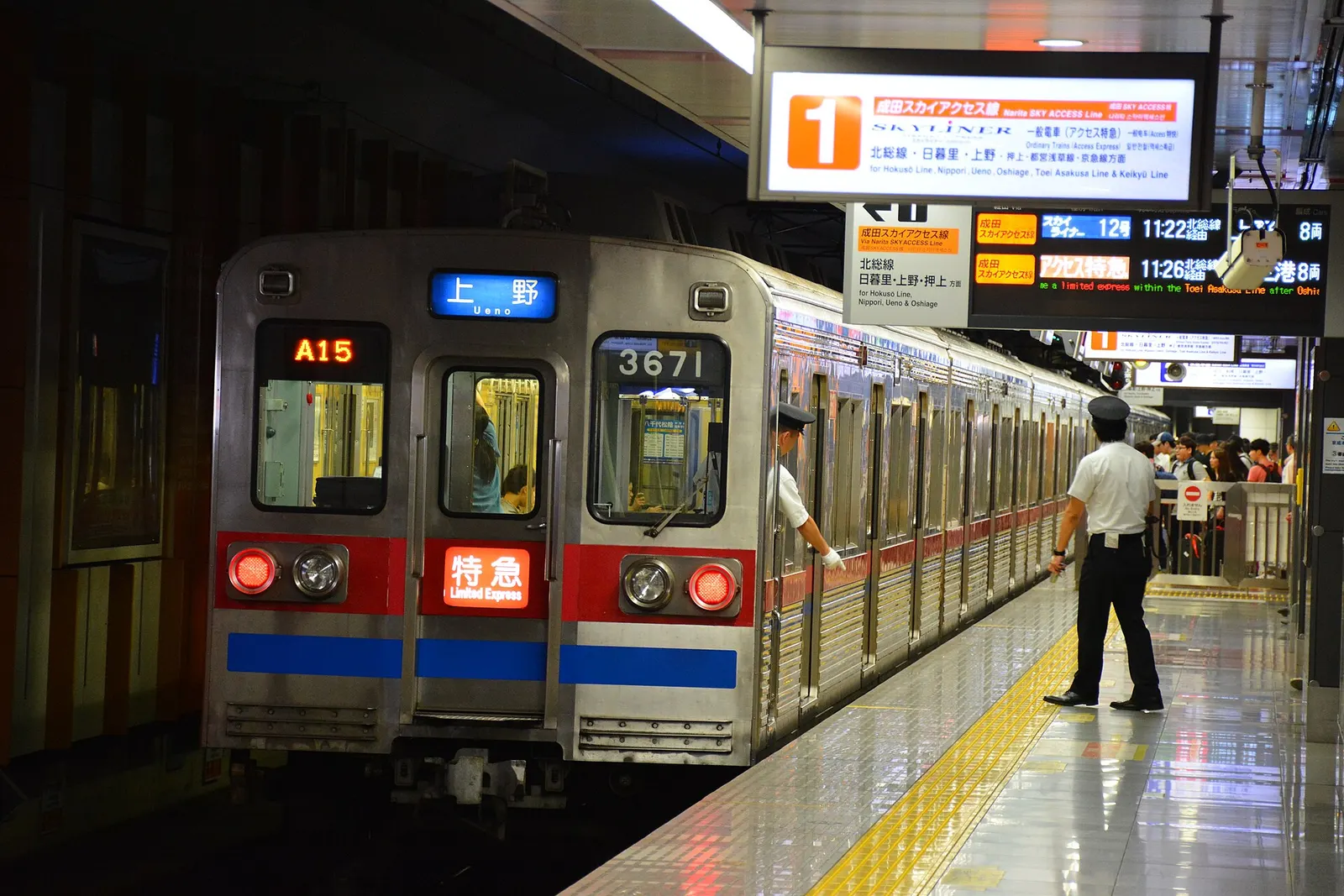 A Keisei Railway limited-express train stopped at Narita Airport Terminal 2–3 Station with platform signs showing a service bound for Ueno.