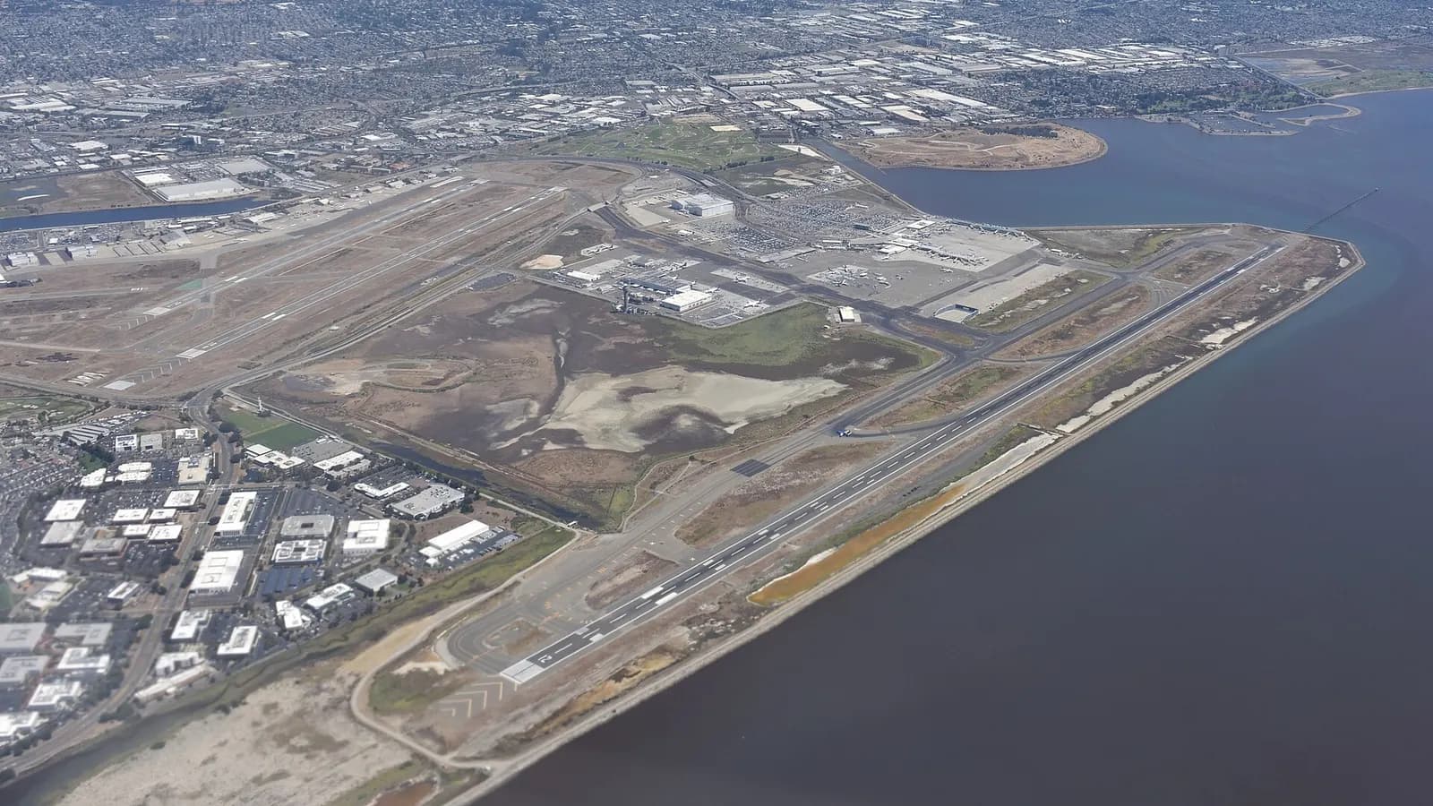 Metropolitan Oakland International Airport, as seen from a plane taking off from San Francisco and headed to Boston. Some blurring on the lower left is due to distortion from the aircraft window.