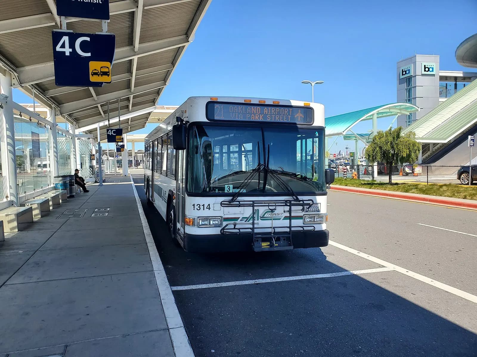 AC transit route 21 bus at Oakland International Airport in April 2024, with the BART station at far right