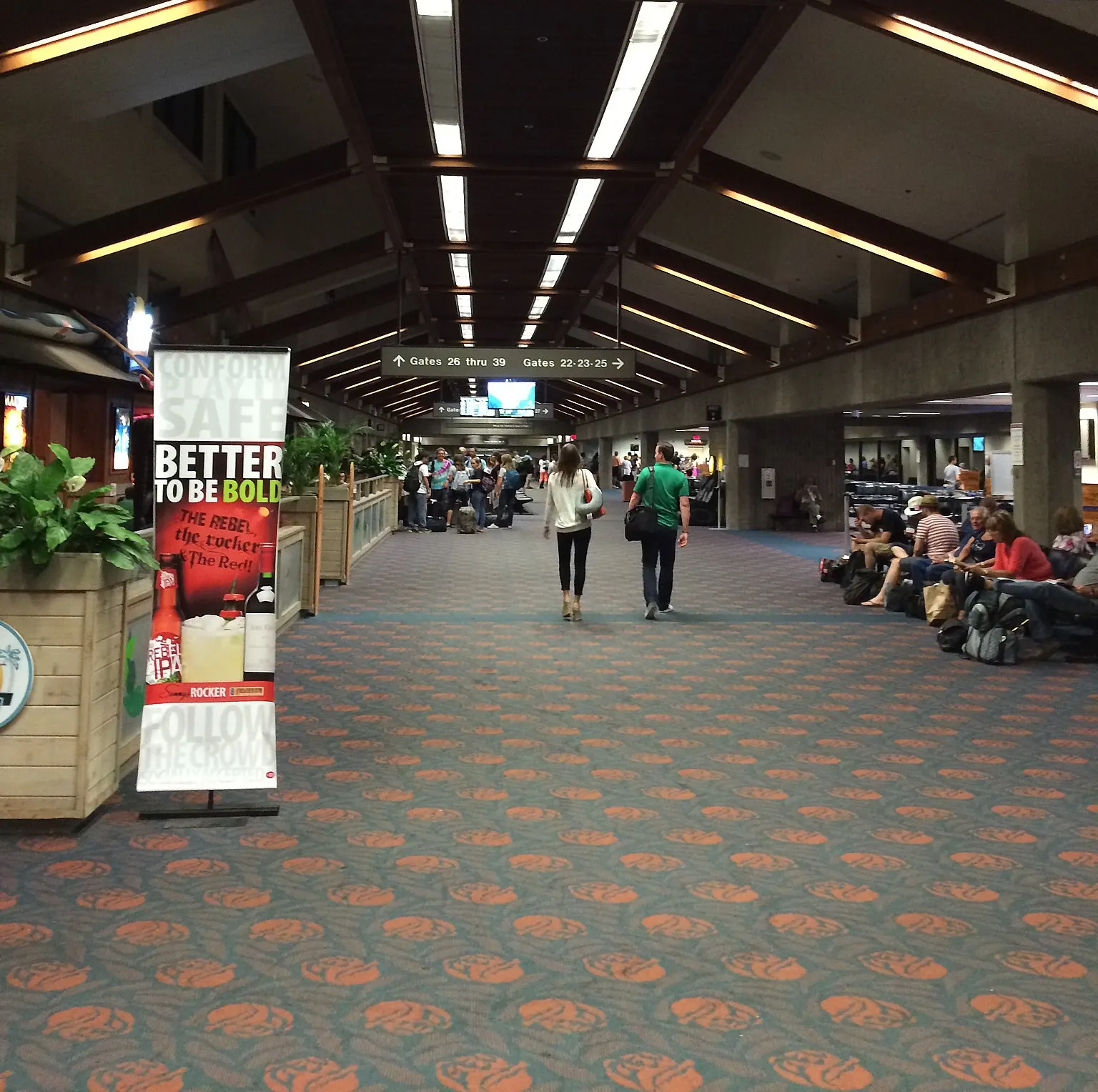 North holdroom at Kahului looking toward Gates 26–39, with a Sammy’s Beach Bar & Grill standee on the left.