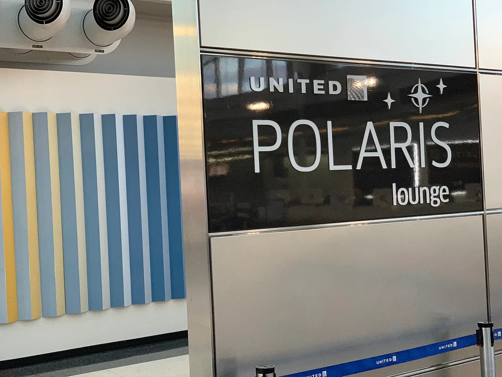 A polished entrance sign marks the United Polaris Lounge near gate C18 in Terminal 1.