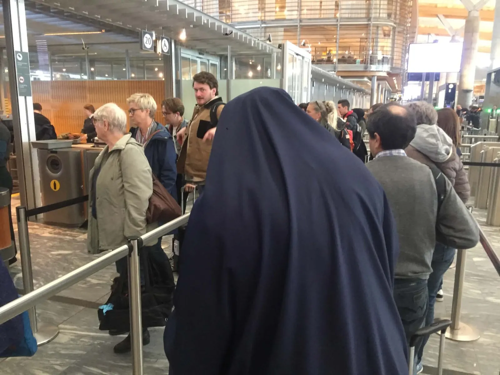 Travelers standing in a queue at the security screening area inside Oslo Airport Gardermoen.