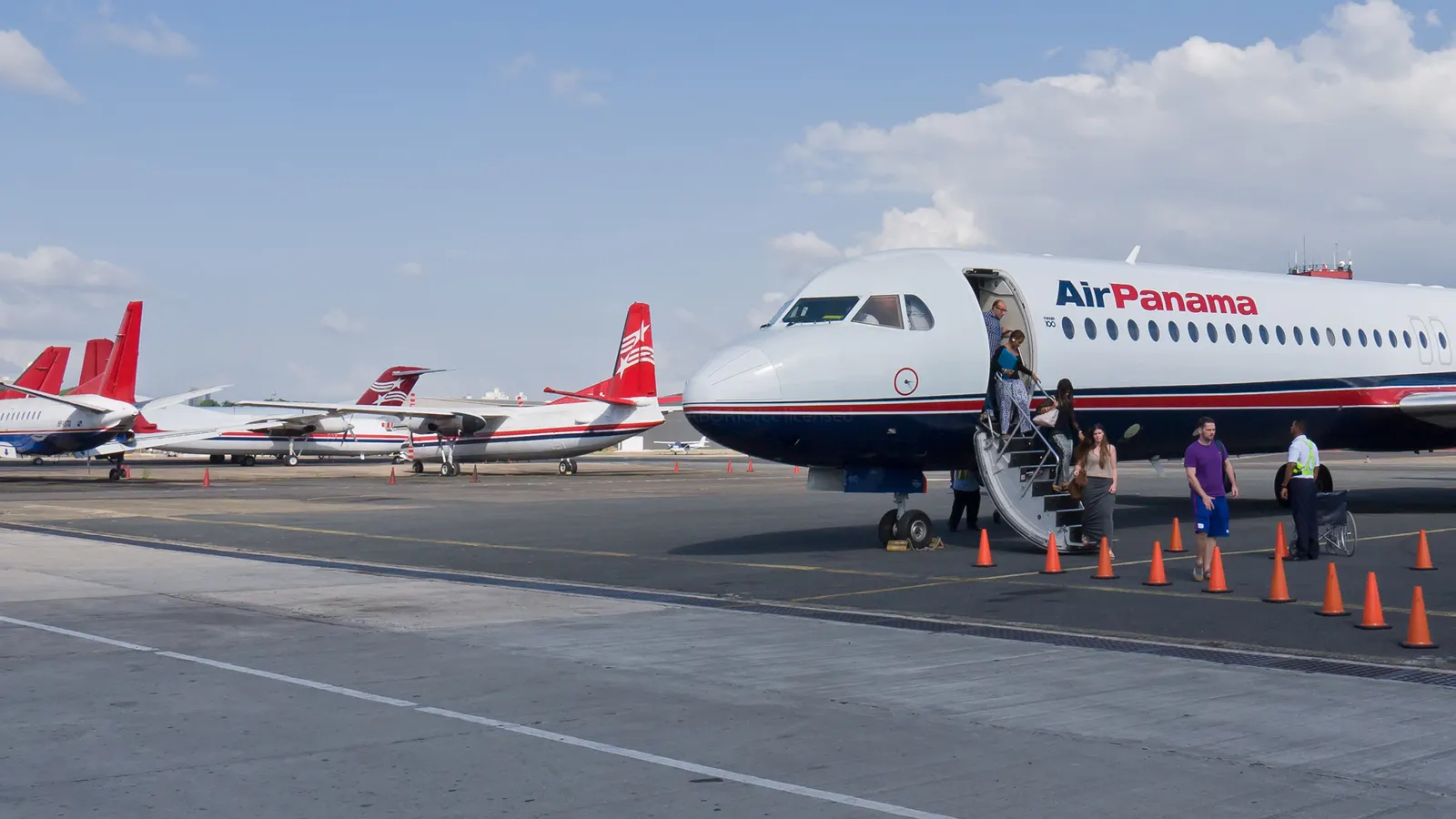 Air Panama Fokker 100 parked beside the low terminal building at Marcos A. Gelabert (PAC) airport.