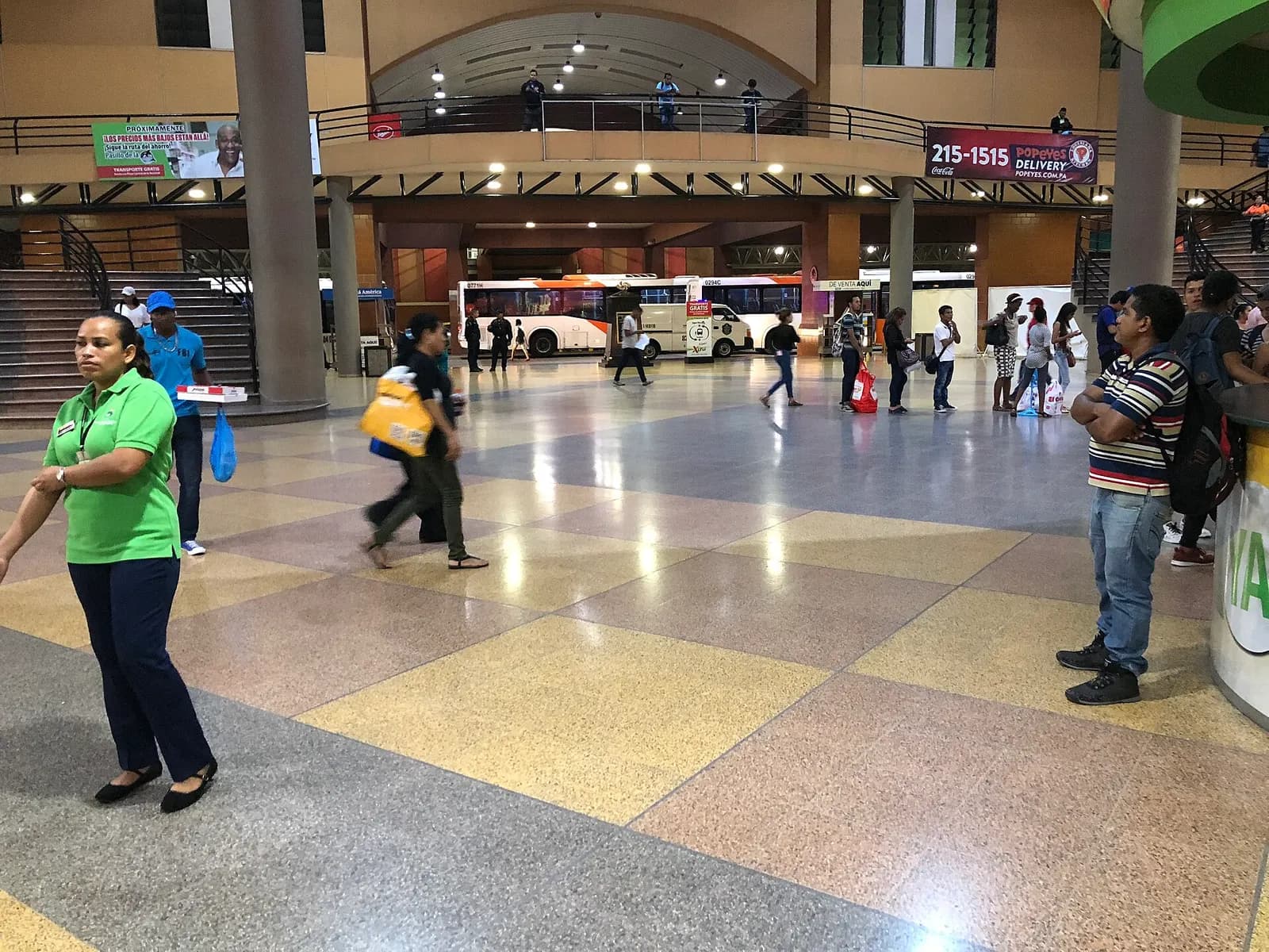 Bus station lobby with glass walls looking out onto parked coaches.