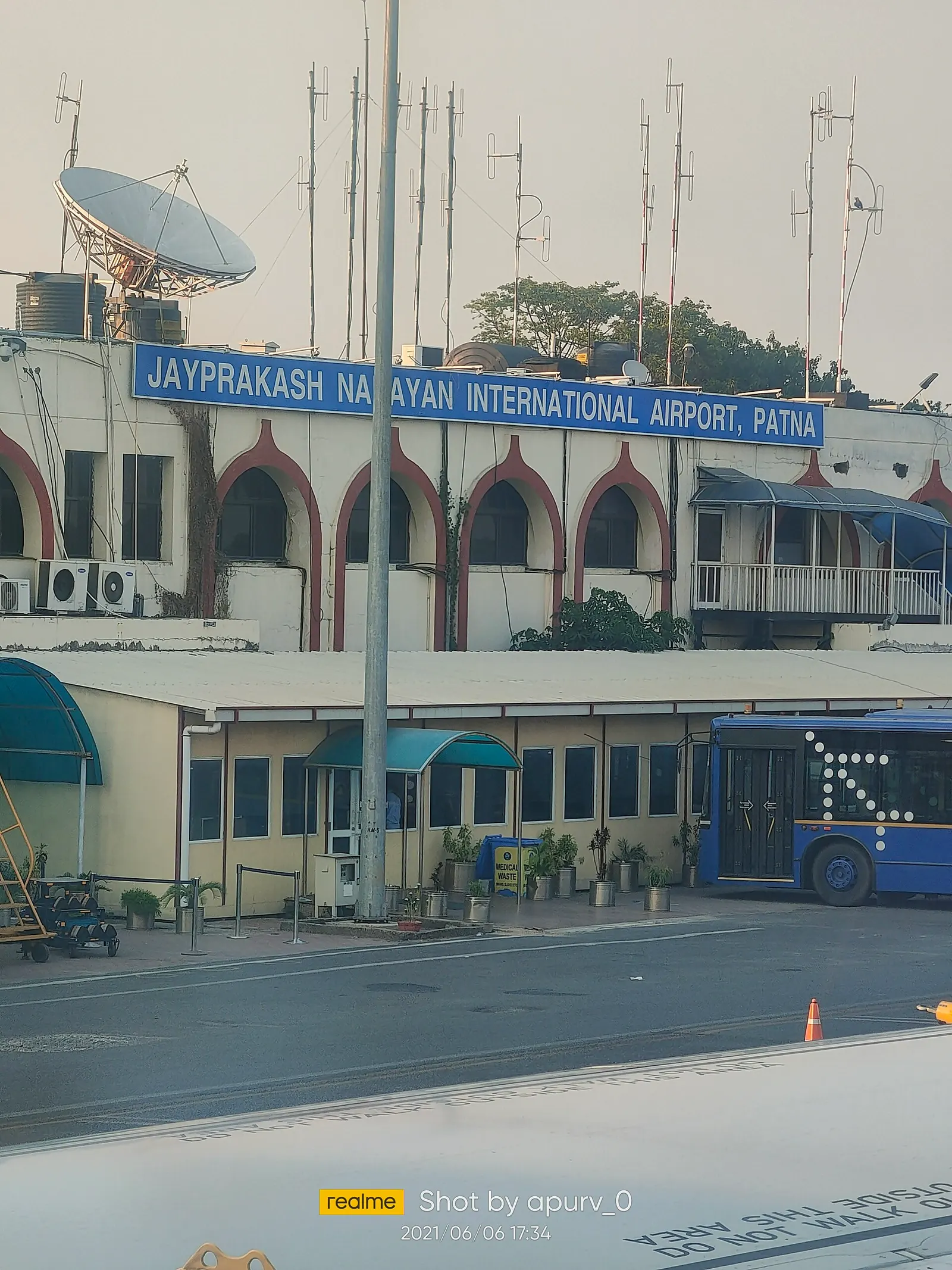 Former Patna airport terminal airside with arched windows and apron shuttle bus (2021)
