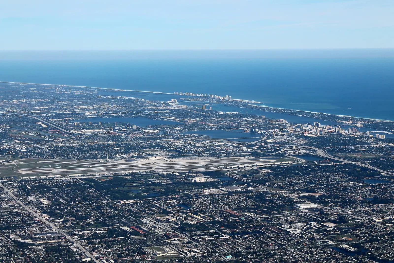 Wider aerial of Palm Beach International Airport and the surrounding Palm Beaches suburbs, showing the runway layout west of downtown West Palm Beach.