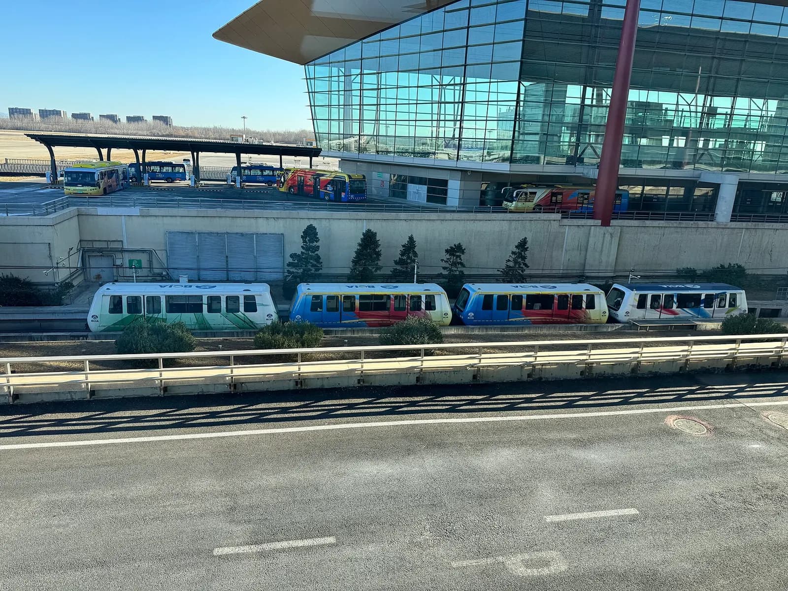 Automated People Mover tram on an elevated guideway inside Terminal 3, connecting the domestic and international concourses.