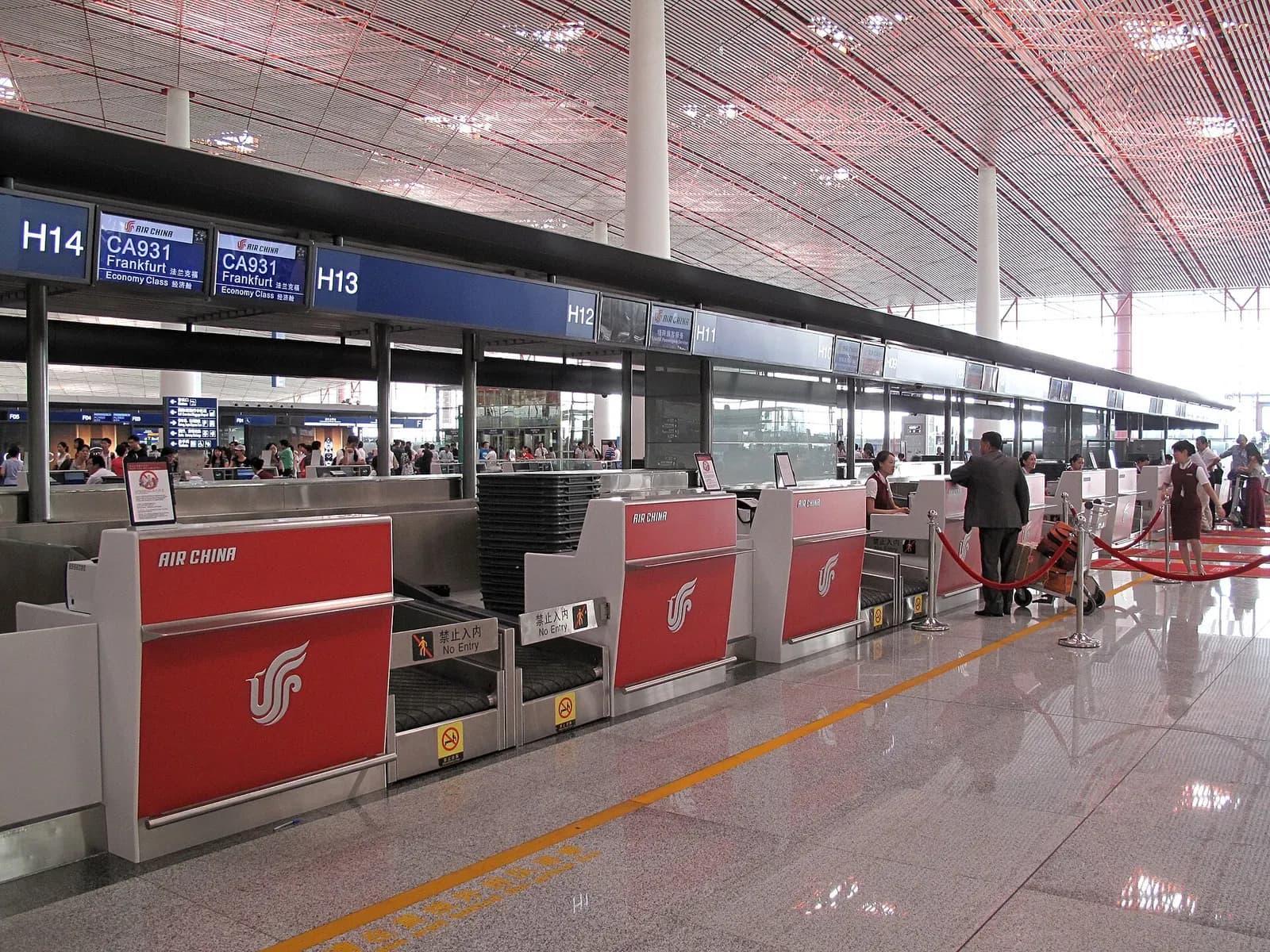 Air China check-in counters with red branding and queue lanes in the Terminal 3 departures area.