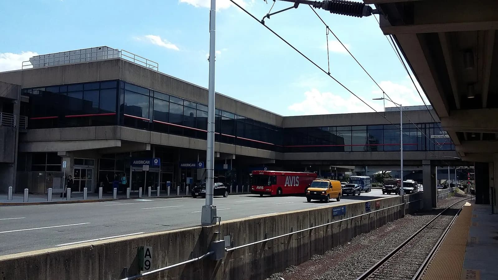 Terminal A and an enclosed pedestrian bridge seen from the SEPTA Regional Rail platform at the Airport station.