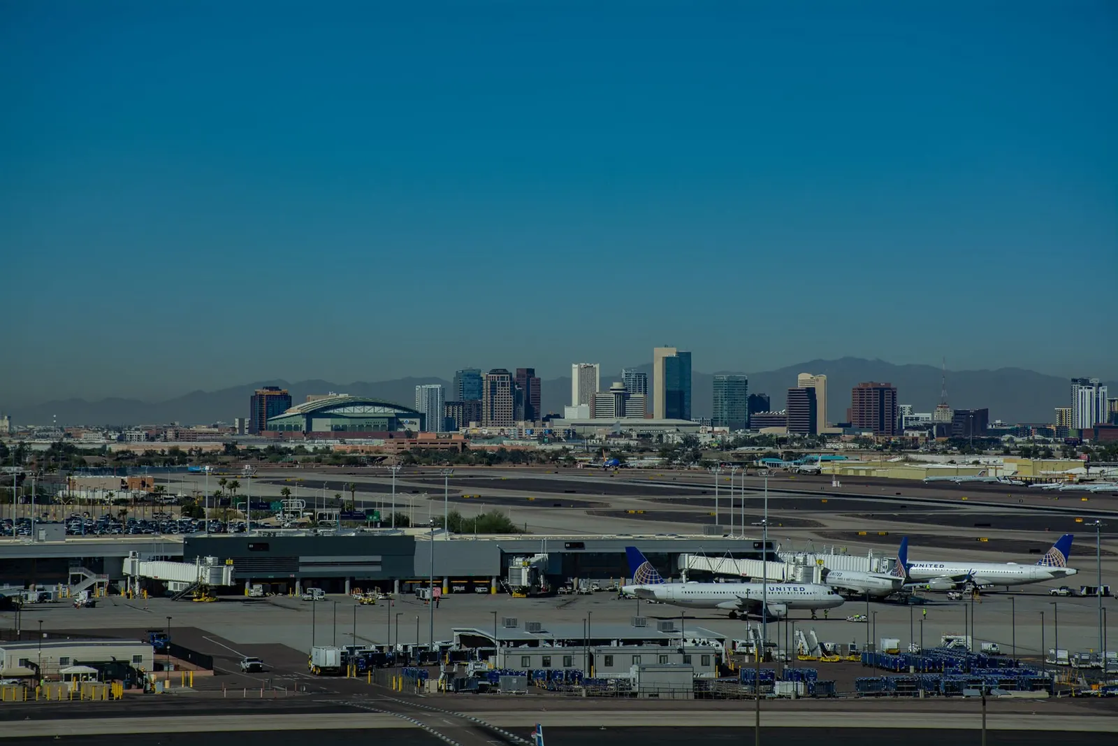 The Phoenix downtown skyline with office towers and mountains, photographed from the top level of the airport parking garage.