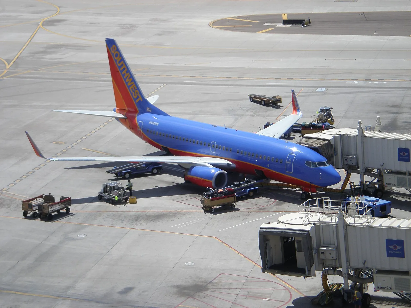 A Southwest Airlines Boeing 737 parked at gate D6 in Terminal 4 with a jet bridge connected to the aircraft.