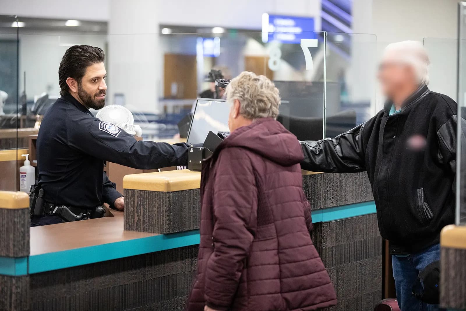 U.S. Customs and Border Protection officers directing arriving international passengers in the baggage claim area.