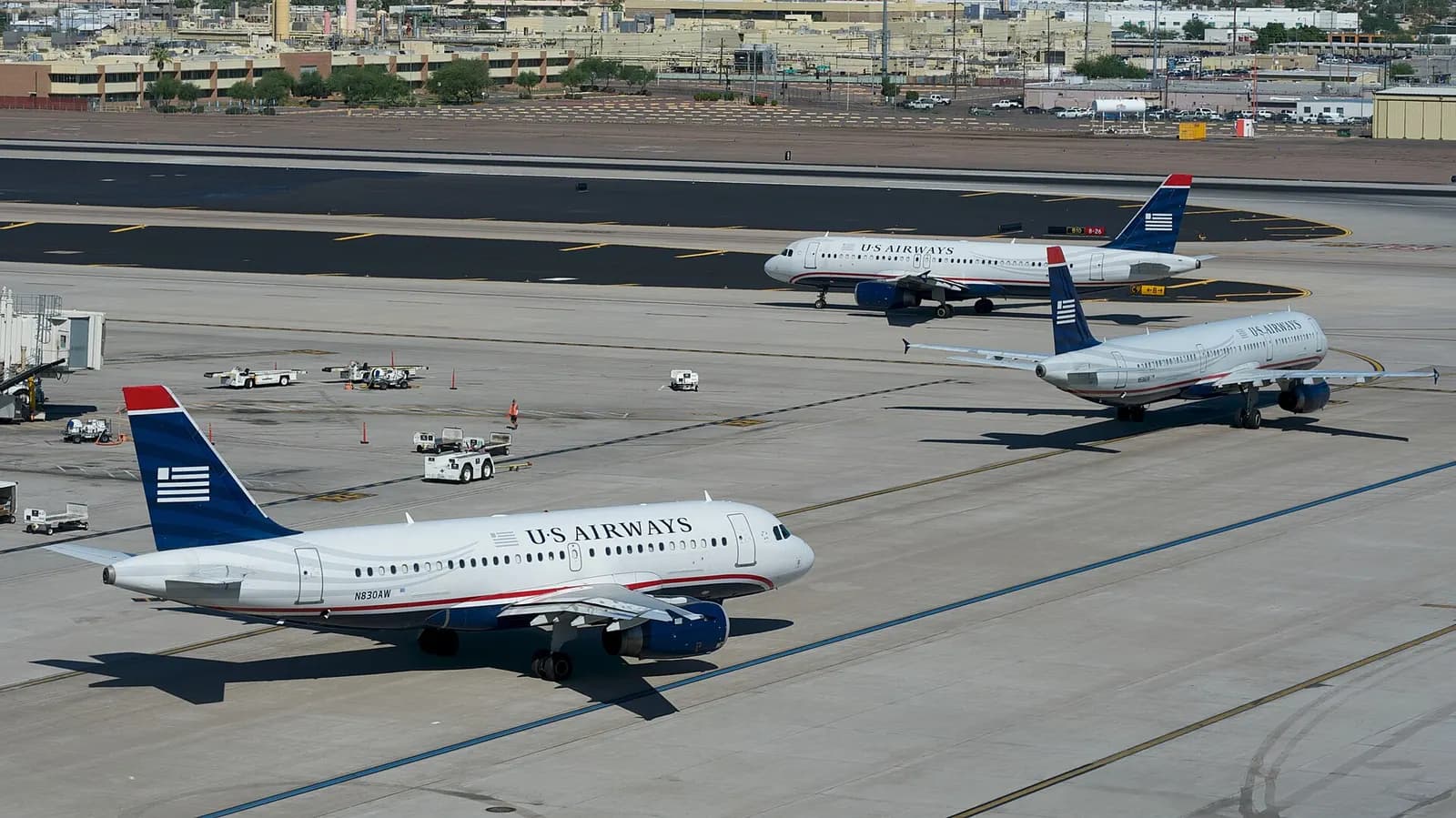 Several US Airways Airbus jets lined up on the taxiway for departure, viewed from the Terminal 4 parking structure.
