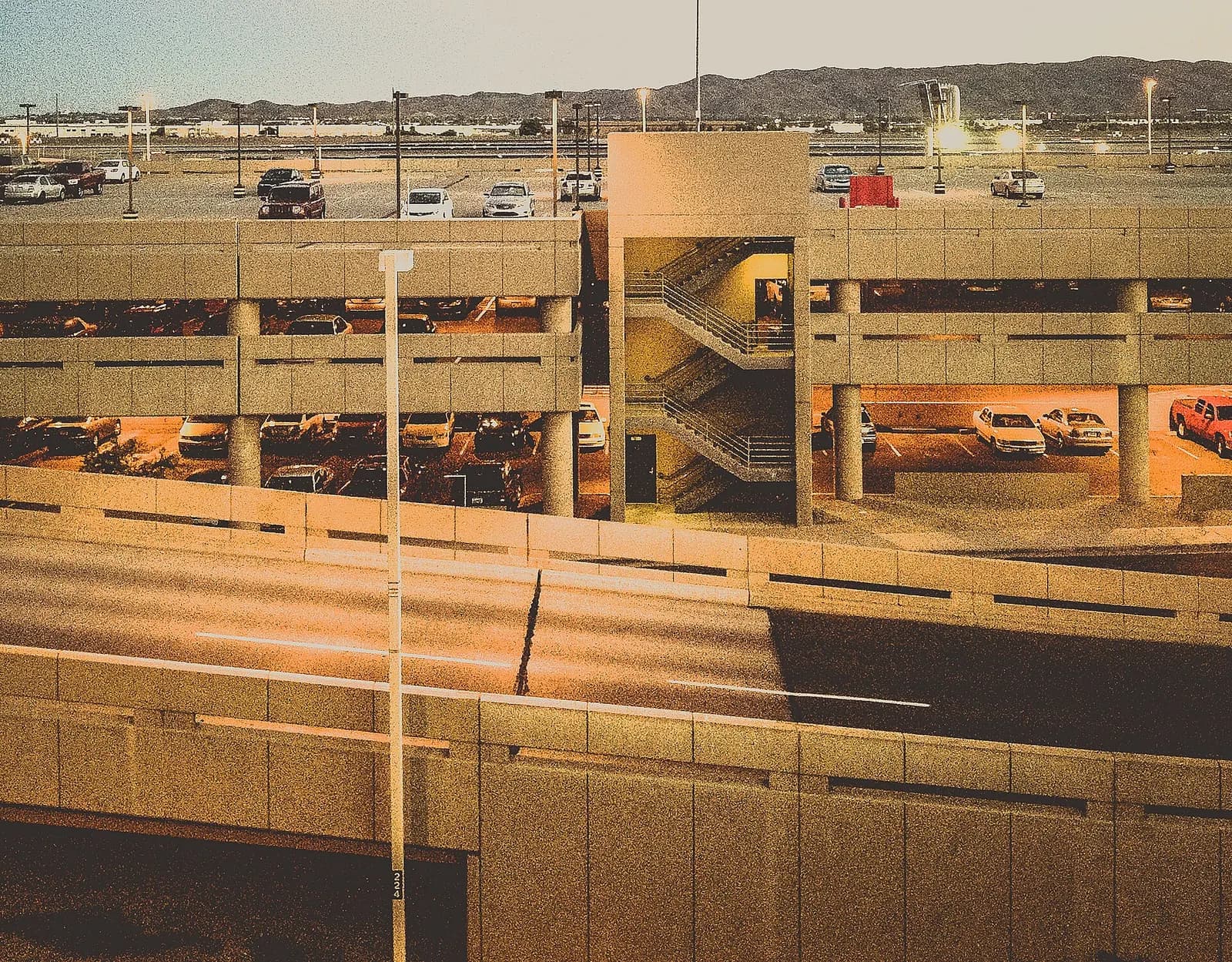 The multi-level open-air parking ramp at Phoenix Sky Harbor with terminal buildings visible beyond the structure.