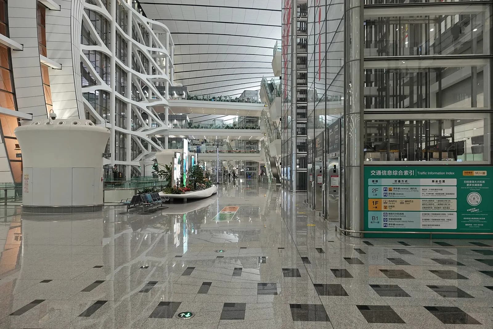 The B1 arrivals level showing wide corridors, wayfinding signs, and connections toward ground transportation.