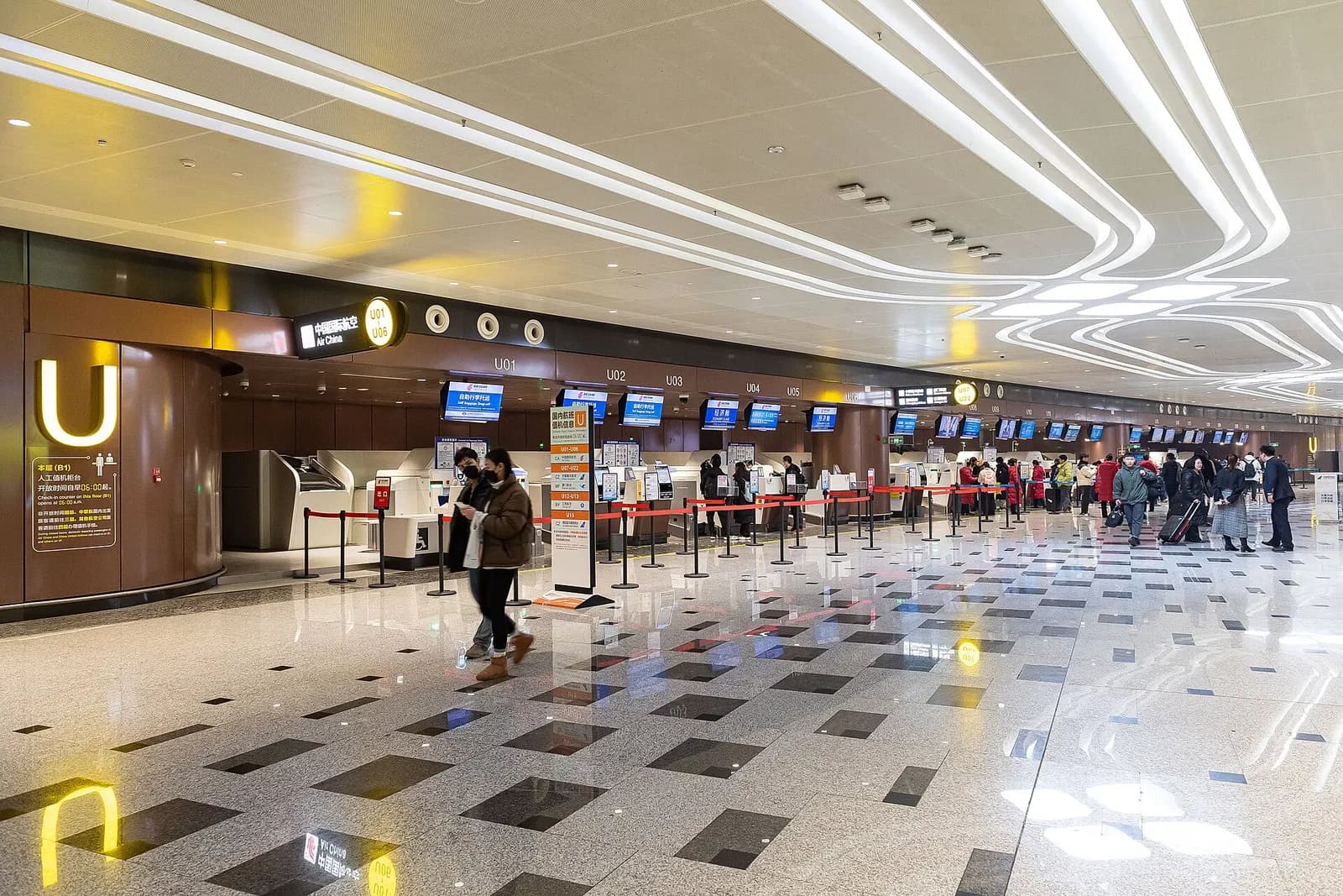 A row of airline check-in counters on the underground B1 level with signage for Air China and other carriers.