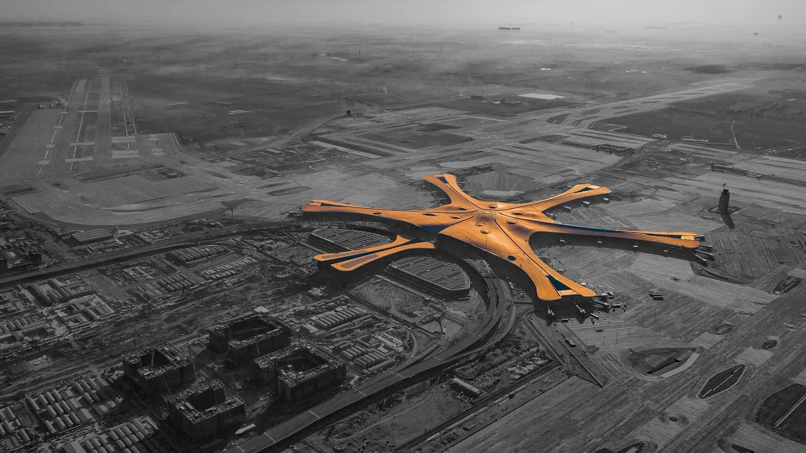 An aerial view of Beijing Daxing International Airport's star-shaped terminal with six radiating concourses and a central hub.