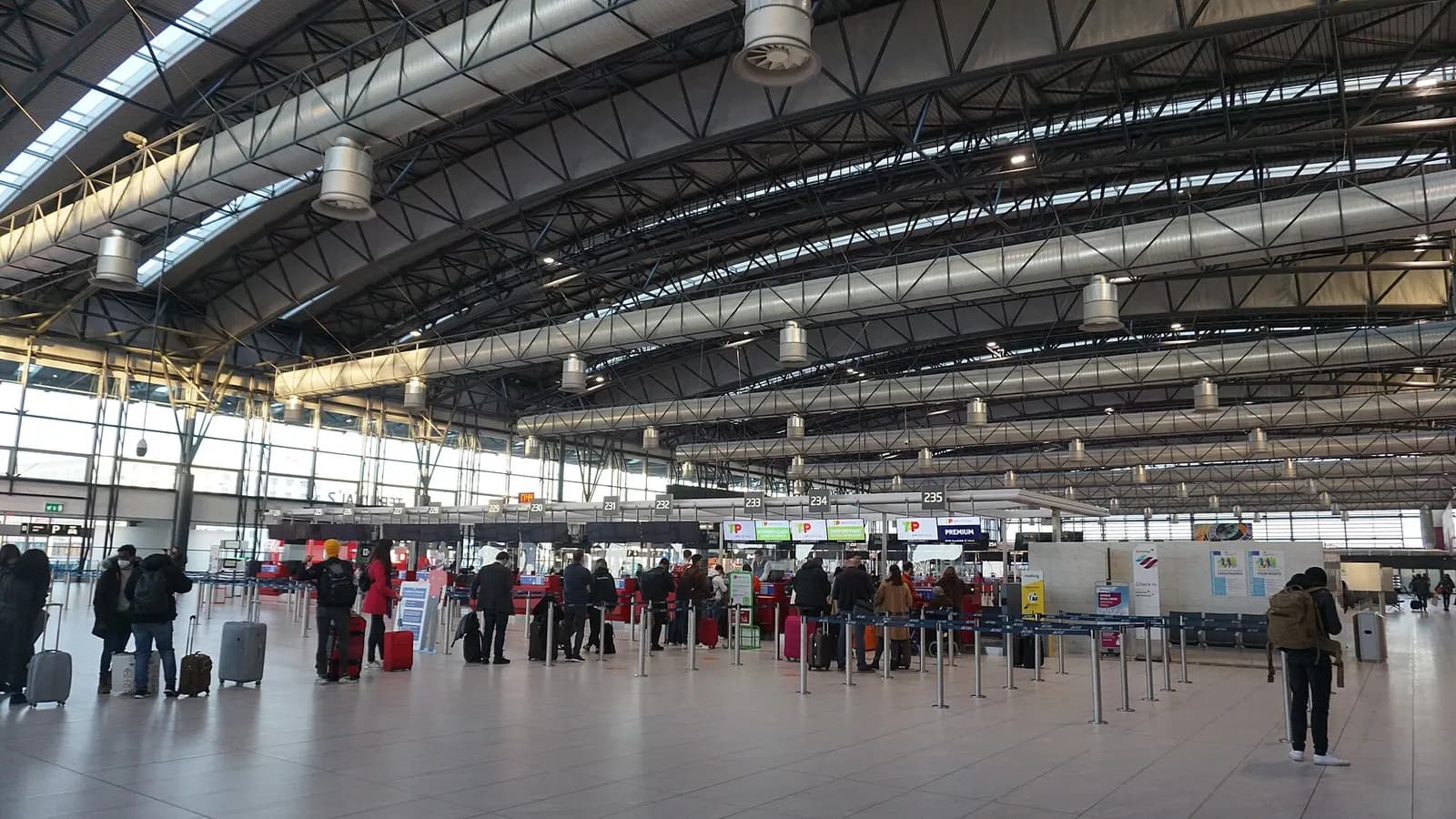 Travelers at airline check-in counters in Terminal 2 of Václav Havel Airport Prague during check-in for an international flight.